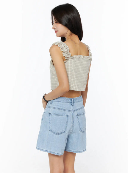 Plaid Ruffle Sleeveless Top CU522 in beige, back view on model, showing open-back silhouette, ruffle strap detail, and plaid fabric, paired with light blue denim shorts.