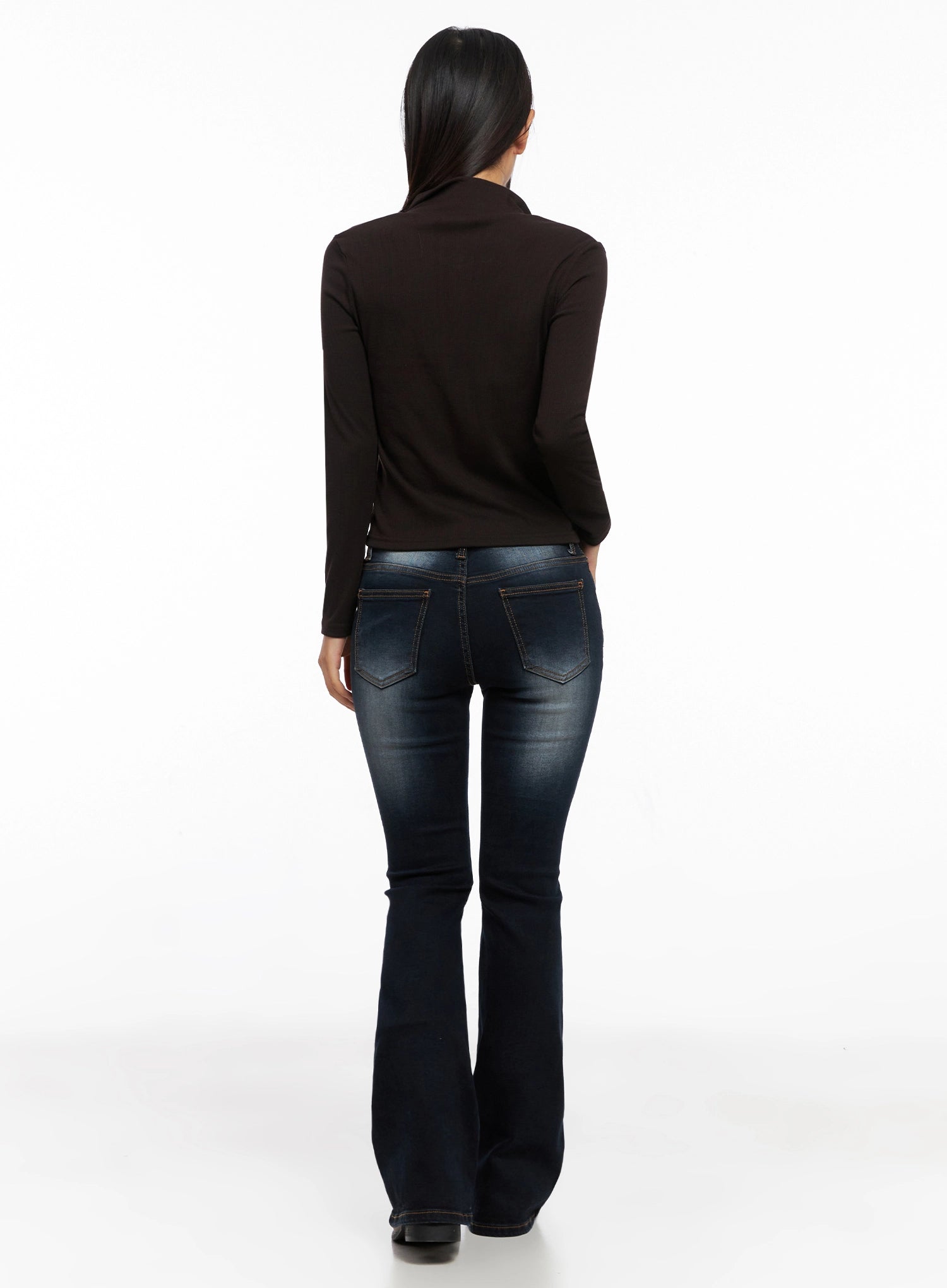 Aliyah Mid-Rise Hip Pad Flared Jeans IG528 in dark blue, back full-length on model, rear patch pockets with contrast stitching and hip pad curve shown, styled with dark brown long sleeve top.