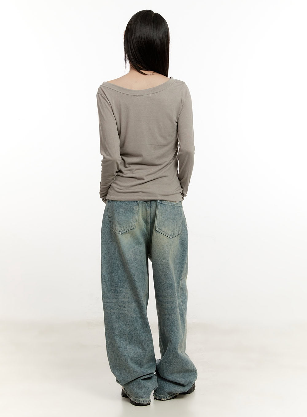 Galinda Washed Baggy Jeans CM513 in vintage blue, full-body back view on model, wide patch back pockets with washed denim finish, layered with taupe long-sleeve top.