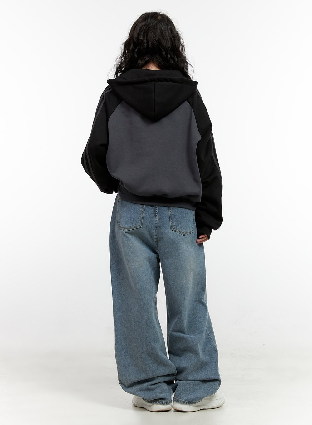 Taryn Chic Wide-Leg Jeans ON404 in light blue, full back view on model, baggy washed denim with wide-leg drape, paired with two-tone grey and black hoodie, white sneakers.