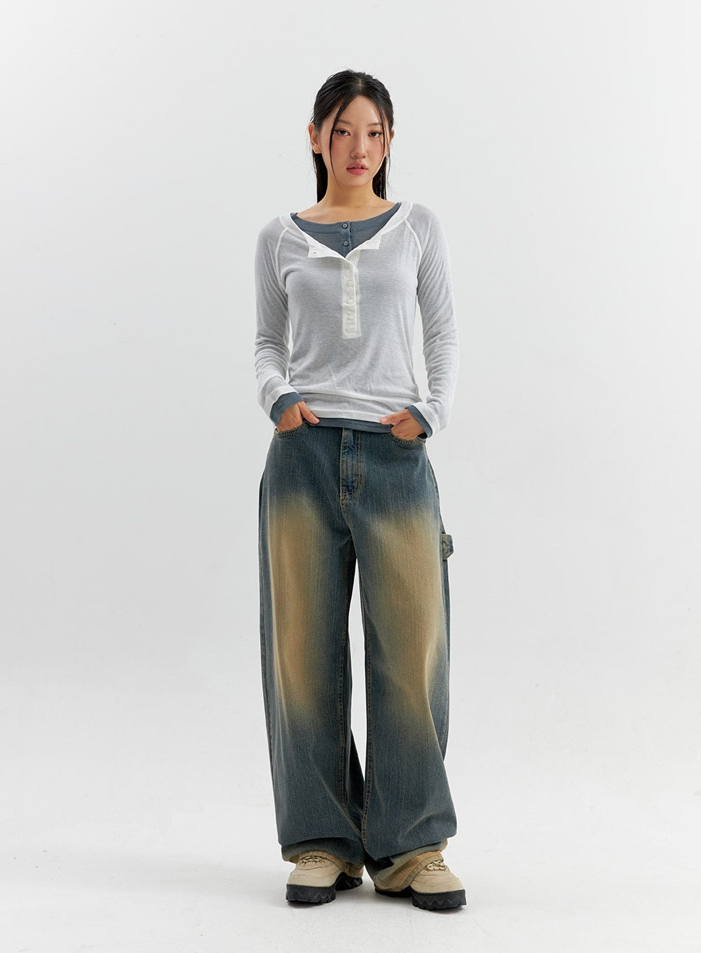 Vintage Wash Wide Leg Jeans CO306 in blue, full-body front view on model, wide-leg vintage-wash denim, yellow fade at thighs, paired with layered white henley top and chunky sneakers.
