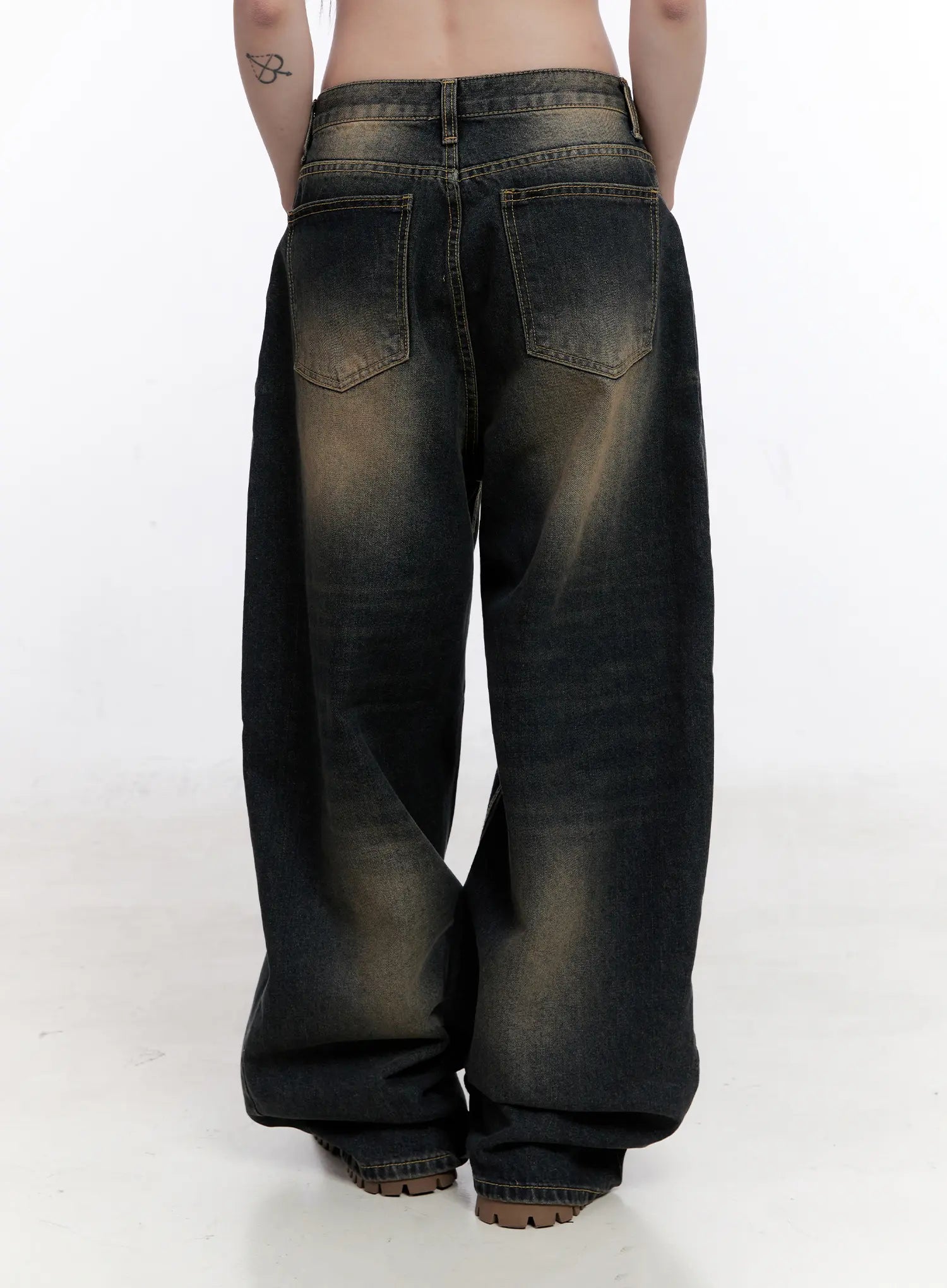 Sylvia Vintage Washed Baggy Jeans CO501 in dark blue, full back view on model, displaying wide-leg baggy silhouette, back pockets, heavy amber-toned vintage wash, and pooling hem at floor.