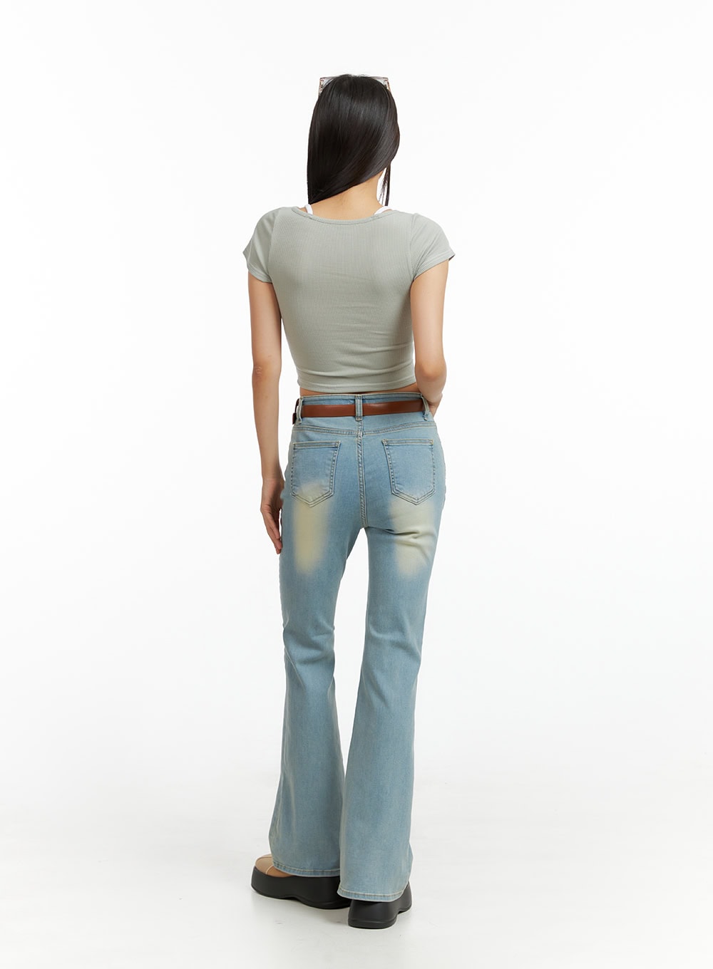Light Washed Slim Fit Bootcut Jeans IL409 in light blue, full back view on model, washed fading on rear, slim fit through legs, subtle bootcut flare, paired with grey crop top.