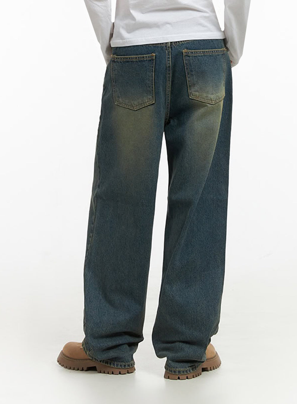Anya Wide Fit Denim Jeans IO409 in blue, back view on model, showing dual back pockets with yellow-tinted washed fade on wide baggy denim, full leg length visible, styled with white long-sleeve tee.
