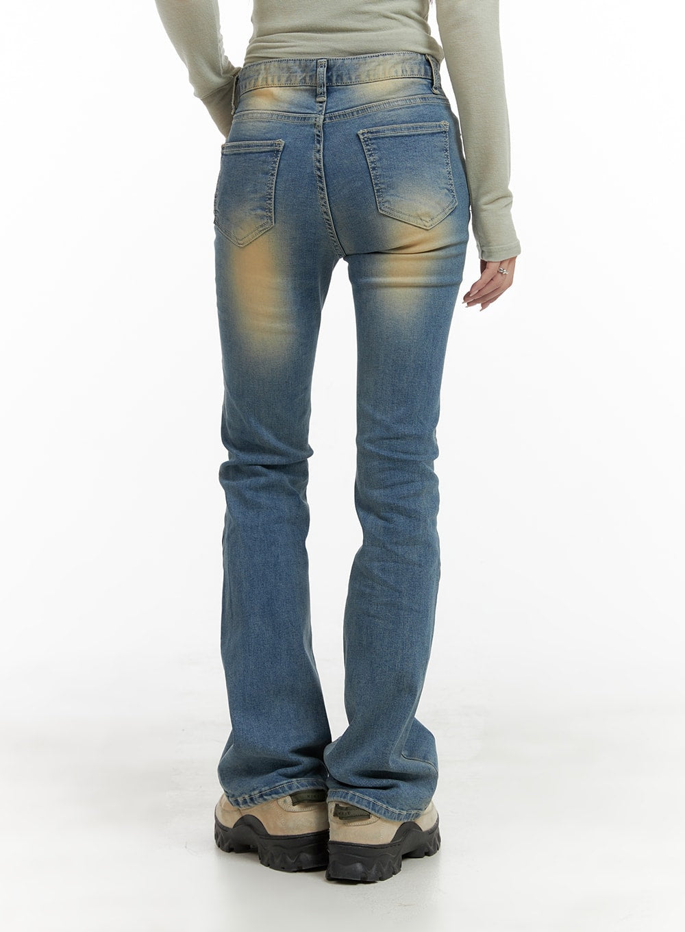 Slim Fit Washed Bootcut Jeans CA402 in blue, full-length back view on model, slim fit bootcut silhouette, washed yellow fading on rear thighs and waistband, paired with sage top and chunky boots.