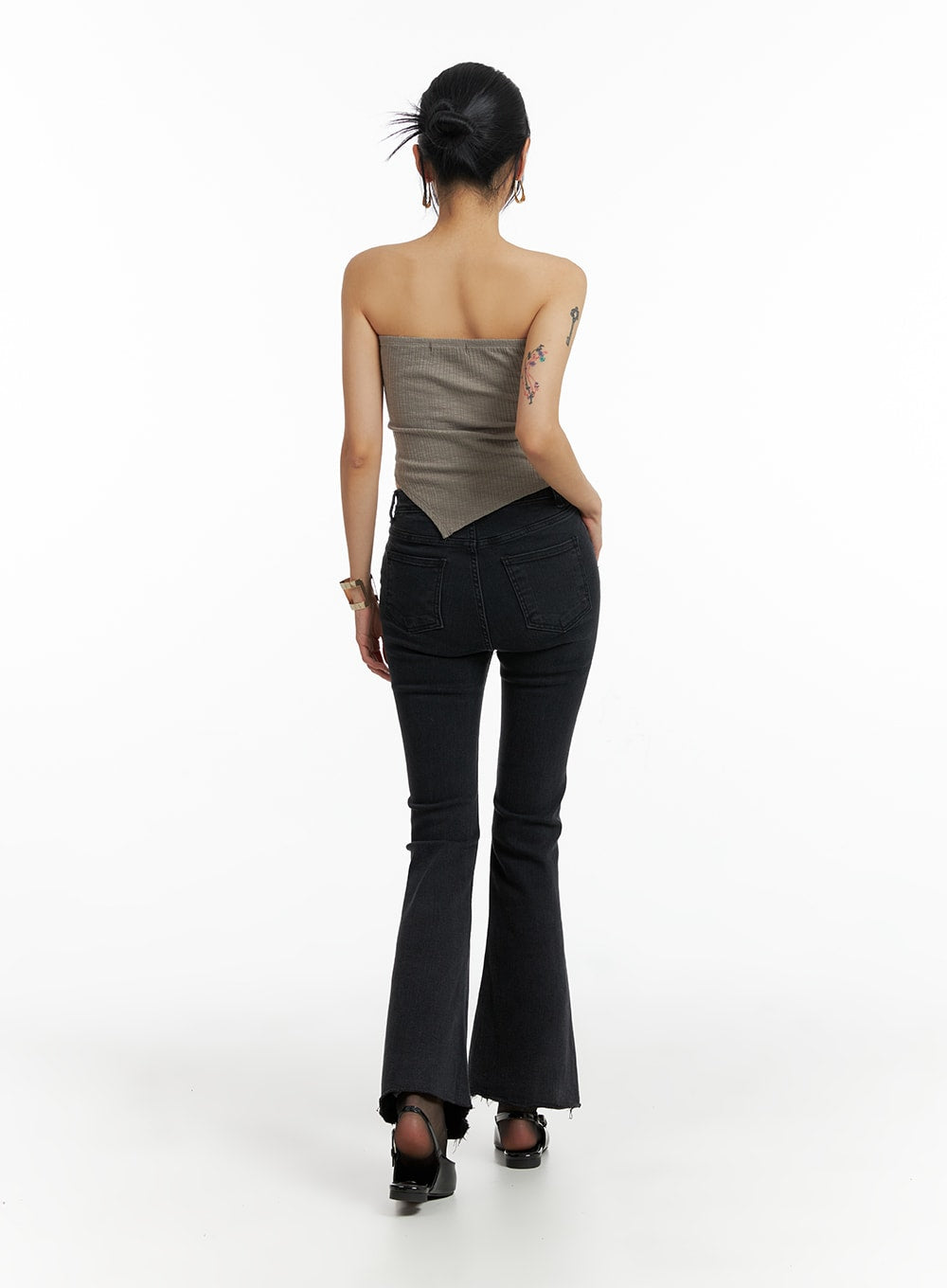 Mid Waist Button Flared Jeans IF402 in dark grey, back full-body editorial shot on model walking, rear pocket detail and slim-to-flare bootcut silhouette with raw hem, paired with mocha bandeau top.