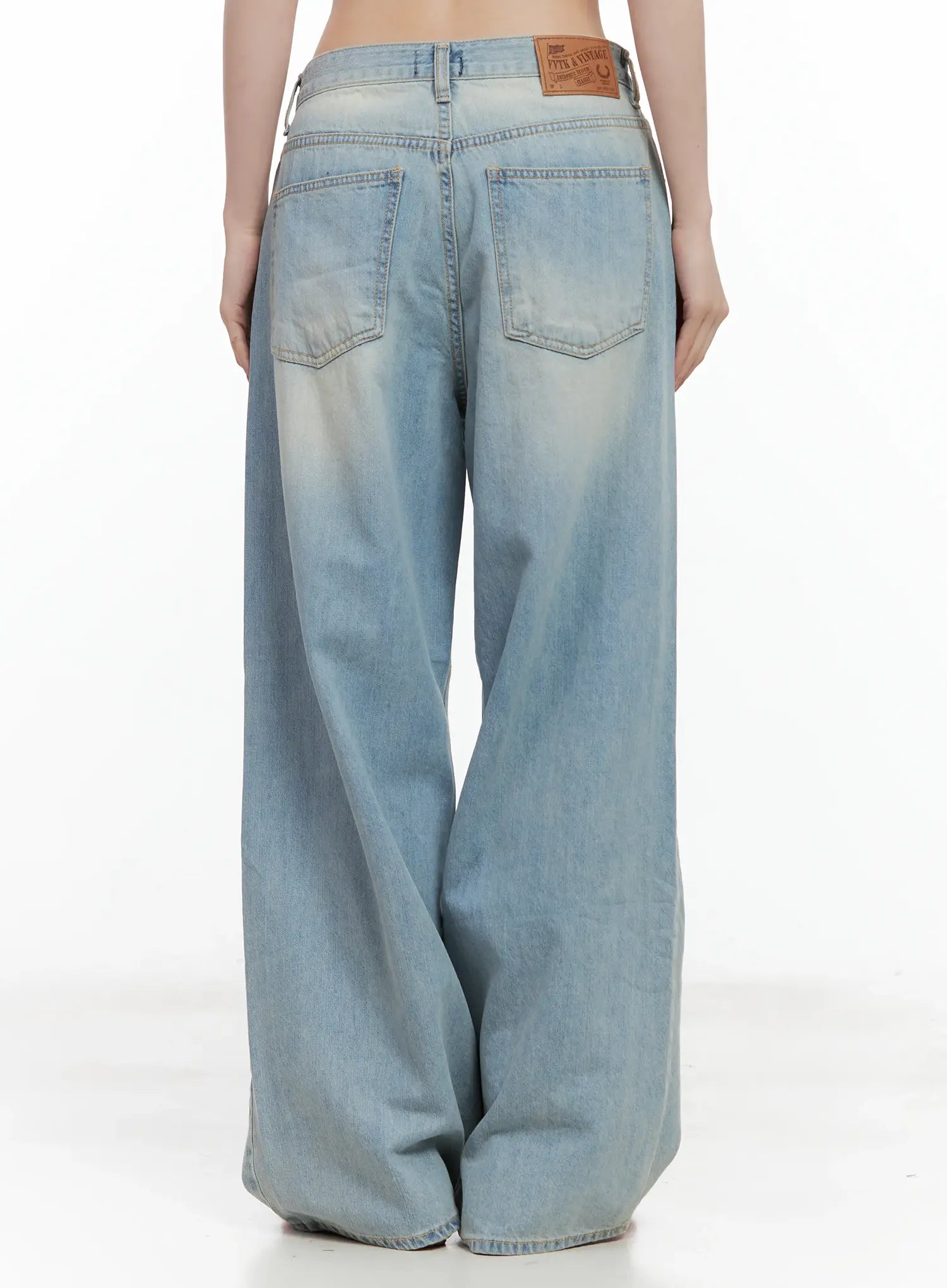 Gyuri Dirty-Wash Distressed Wide Jeans CU530 in blue, back view product shot on model, two back pockets with leather patch label, light dirty-wash wide-leg cotton denim.