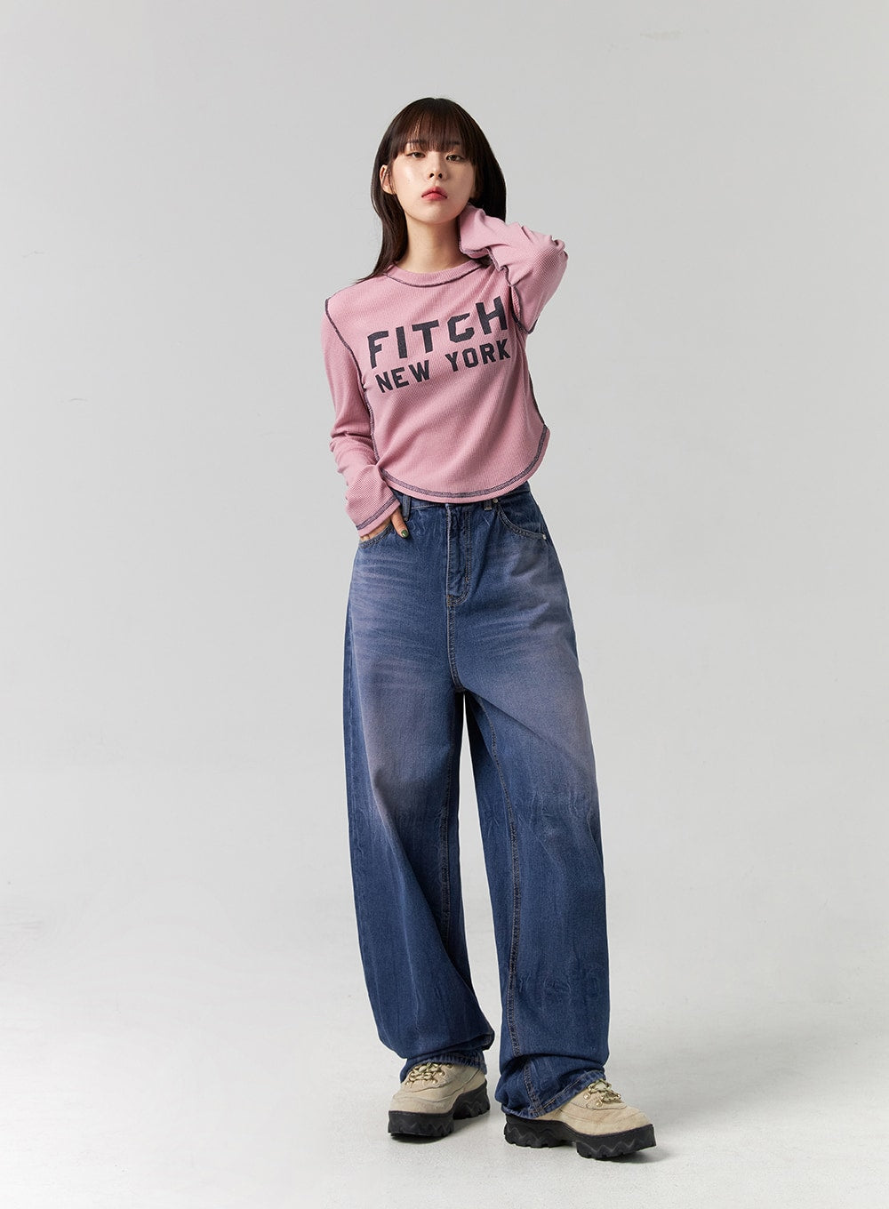 Wide Leg Cotton Jeans CG331 in blue, full front view on model with hand in hair, casual relaxed pose, washed wide-leg denim paired with pink graphic crop tee and sneakers.