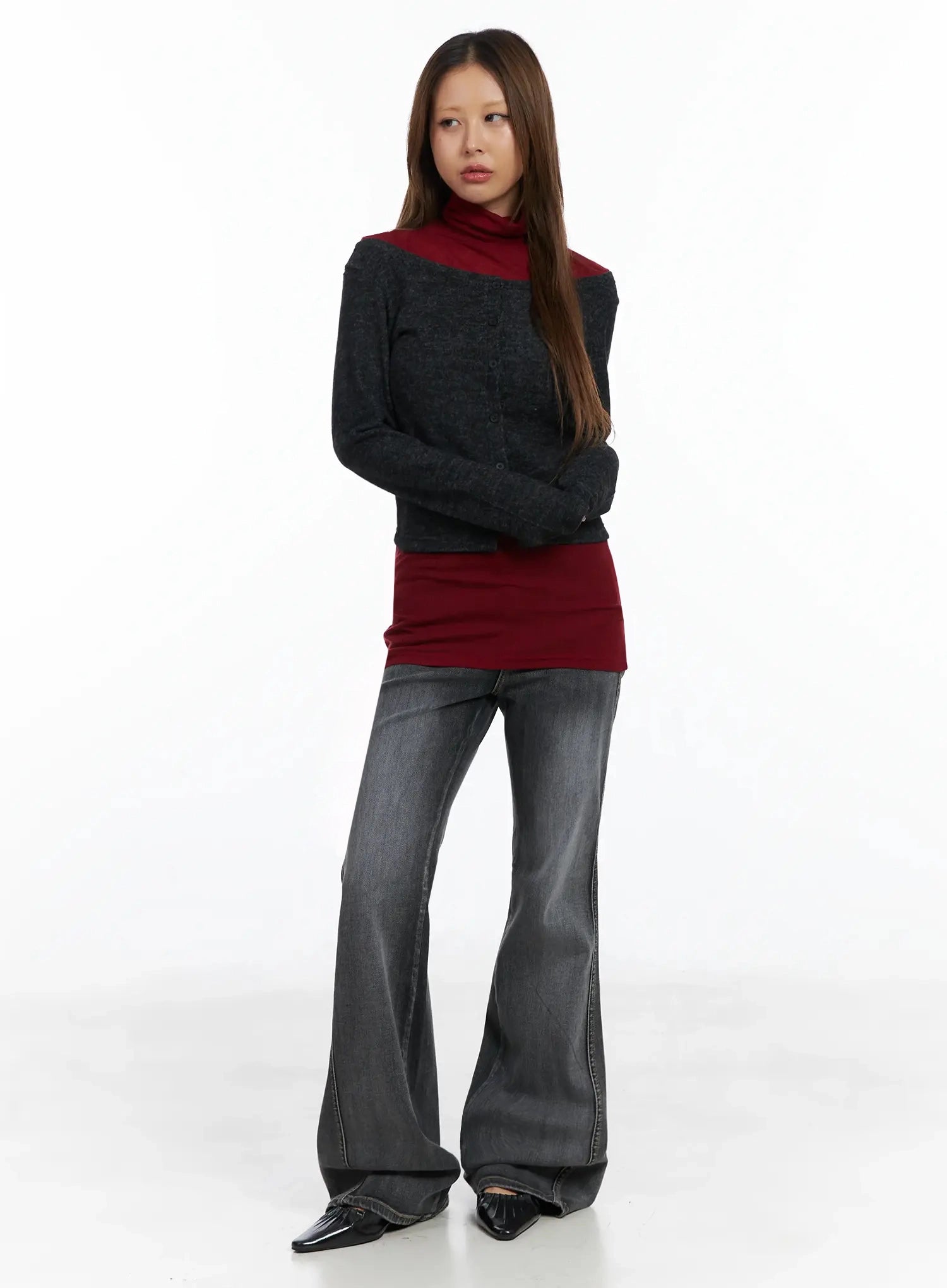 Phoe Flared Jeans ID503 in washed grey, full-length front view on model, layered styling with dark grey cardigan over burgundy turtleneck, flared long hem pooling at floor.