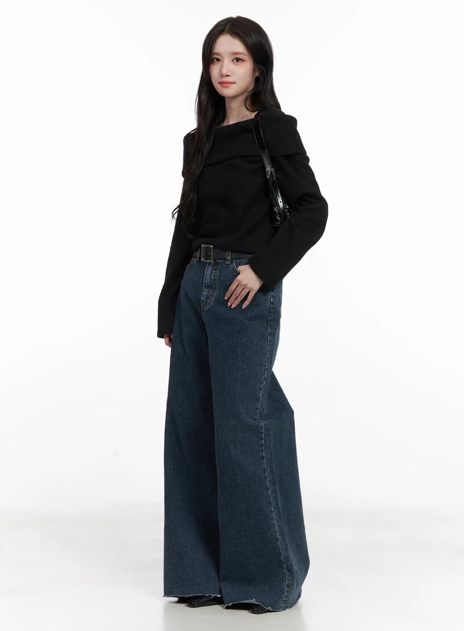 Louisa Ultra Wide Flared Jeans CN527 in dark blue, three-quarter front view on model, ultra wide flared washed denim with black belt, styled with black off-shoulder top and black shoulder bag.