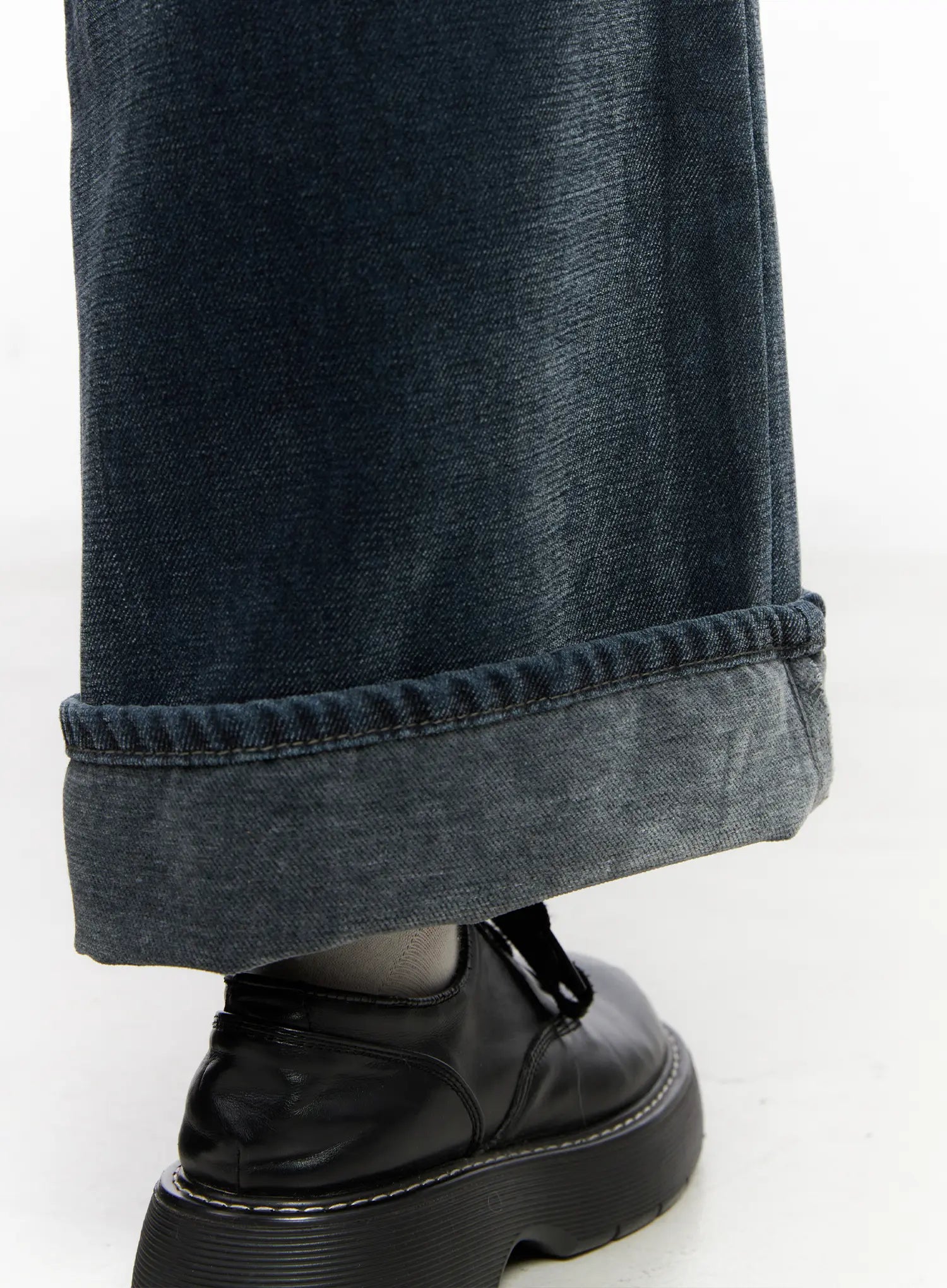 Zariah Baggy Jeans CN526 in dark blue, hem detail close-up, rolled cuff revealing lighter washed inner denim, paired with chunky black platform shoes.