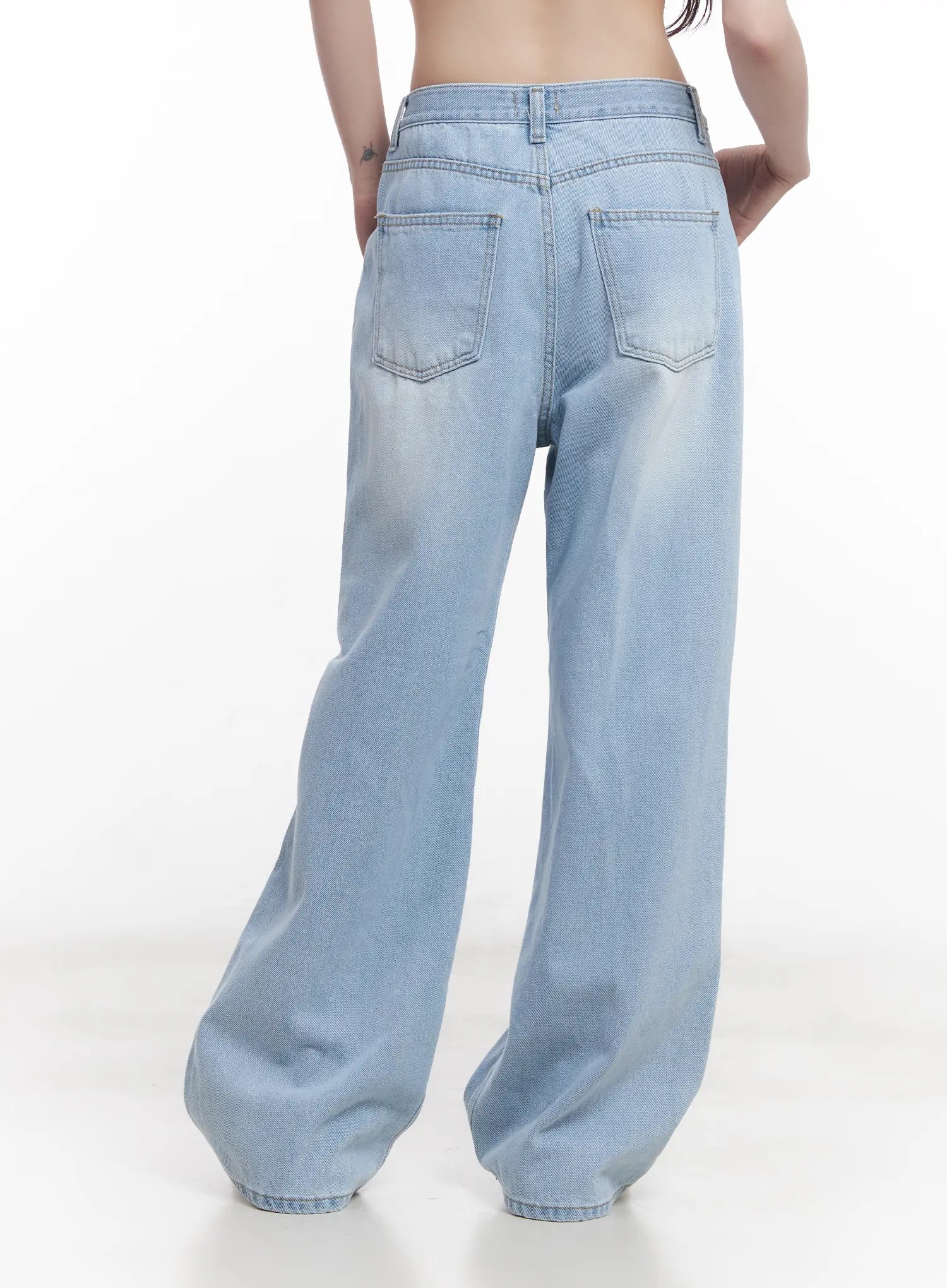 Haerin Washed Wide-Leg Jeans CU519 in light blue, back close-up on model, dual back pockets with decorative stitching and washed fade detail clearly visible, wide-leg cotton denim.