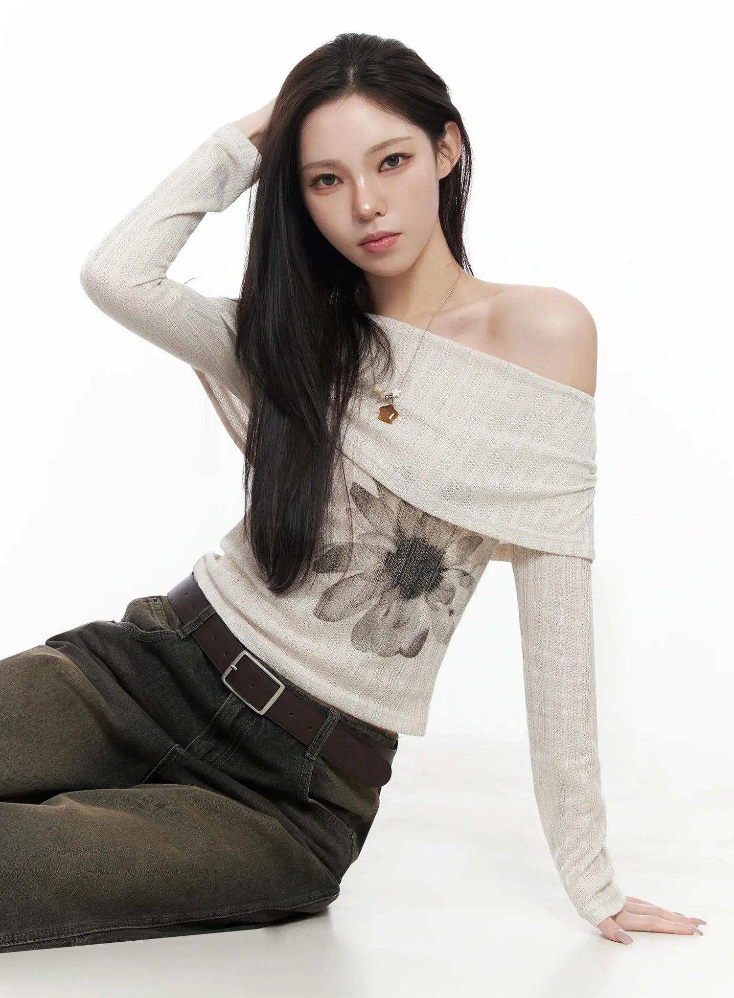 Tracey Vintage Black Washed Wide Leg Jeans IJ528 in black, editorial seated close-up on model, vintage brown-washed wide leg denim, styled with off-shoulder floral knit, brown leather belt.