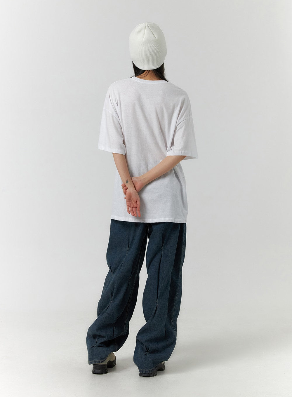 Quilted Wide Leg Denim CF406 in dark blue, full-length back view on model, wide-fit washed denim with quilted pintuck detail visible from rear, paired with white oversized tee and beanie.