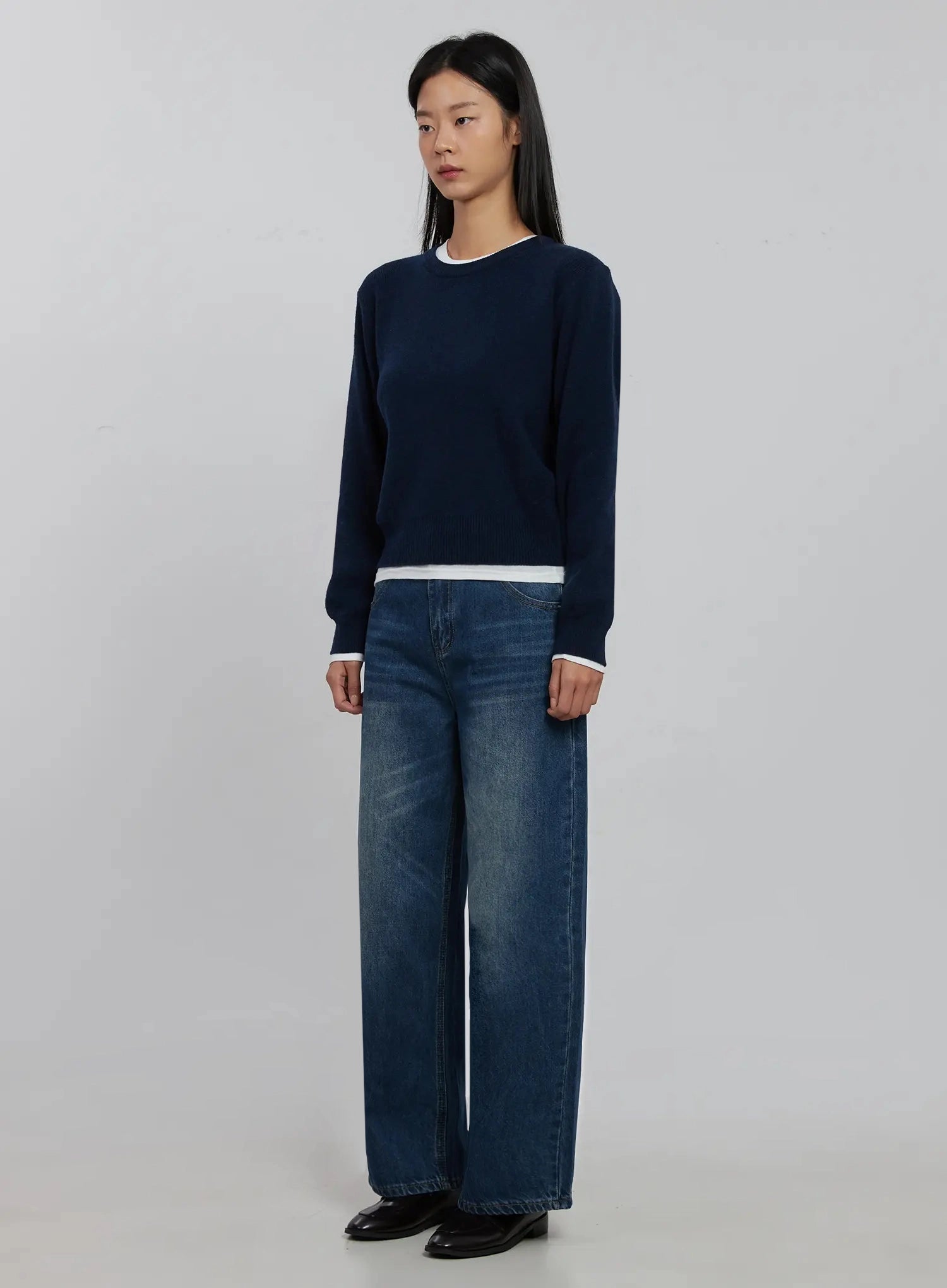 Alaina Wide Leg Jeans IJ508 in dark blue, 3/4 angle full-length on model styled with navy white-trim knit, showing relaxed wide-leg drape and long inseam.