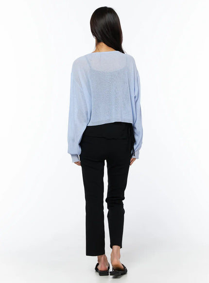 Hip-Pad Capri Pants CU522 in black, back styling shot on model, capri-length straight leg visible beneath light blue sheer knit cardigan with tie detail.