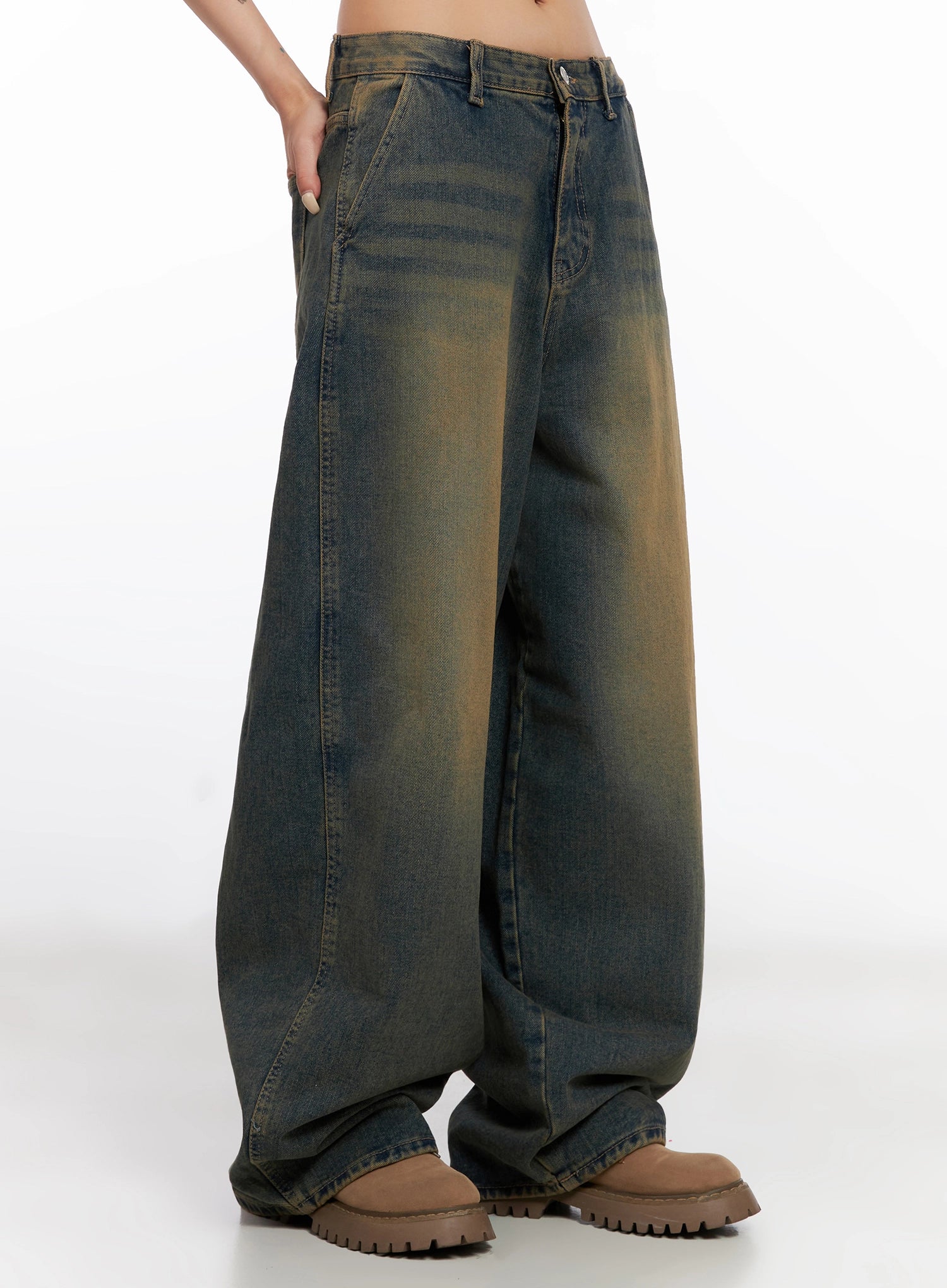 Minju Vintage Washed Baggy Jeans IS508 in dark blue, side close-up on model from waist to hem, highlighting seam lines, yellow vintage wash fade across wide baggy leg, brown boots.