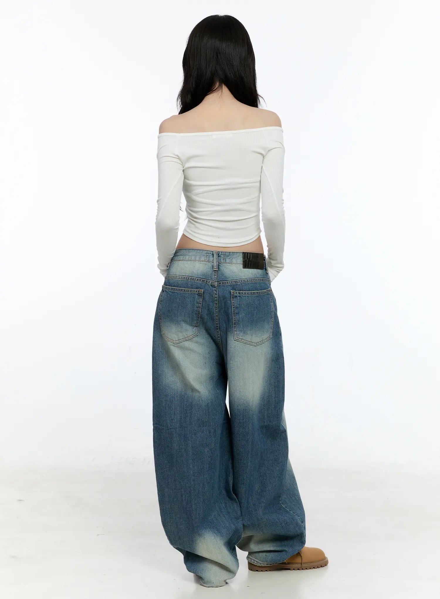 Jiso Baggy Wide Jeans CN517 in blue, back full-body shot on female model, back pockets and brand patch label visible, extra-wide leg hem pooling on floor, paired with white crop top.