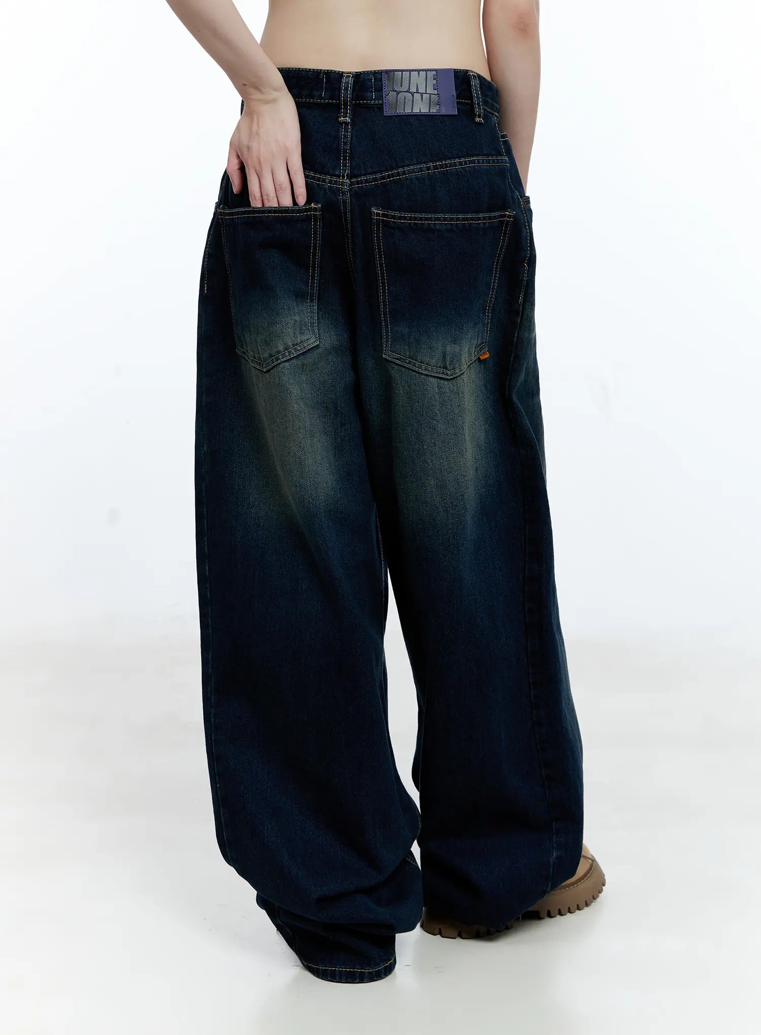Jinnie Washed Wide-Leg Jeans CG511 in dark blue, back close-up on model, highlighting back patch pockets, brand waistband label, contrast stitching, and washed indigo fading detail.