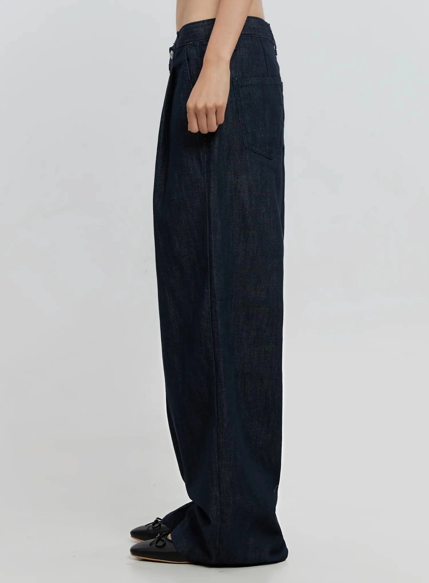 Elio Pintuck Wide-Leg Jeans IS516 in dark indigo, side view from waist to hem on model, showing wide-leg volume and long inseam pooling at black ballet flats.