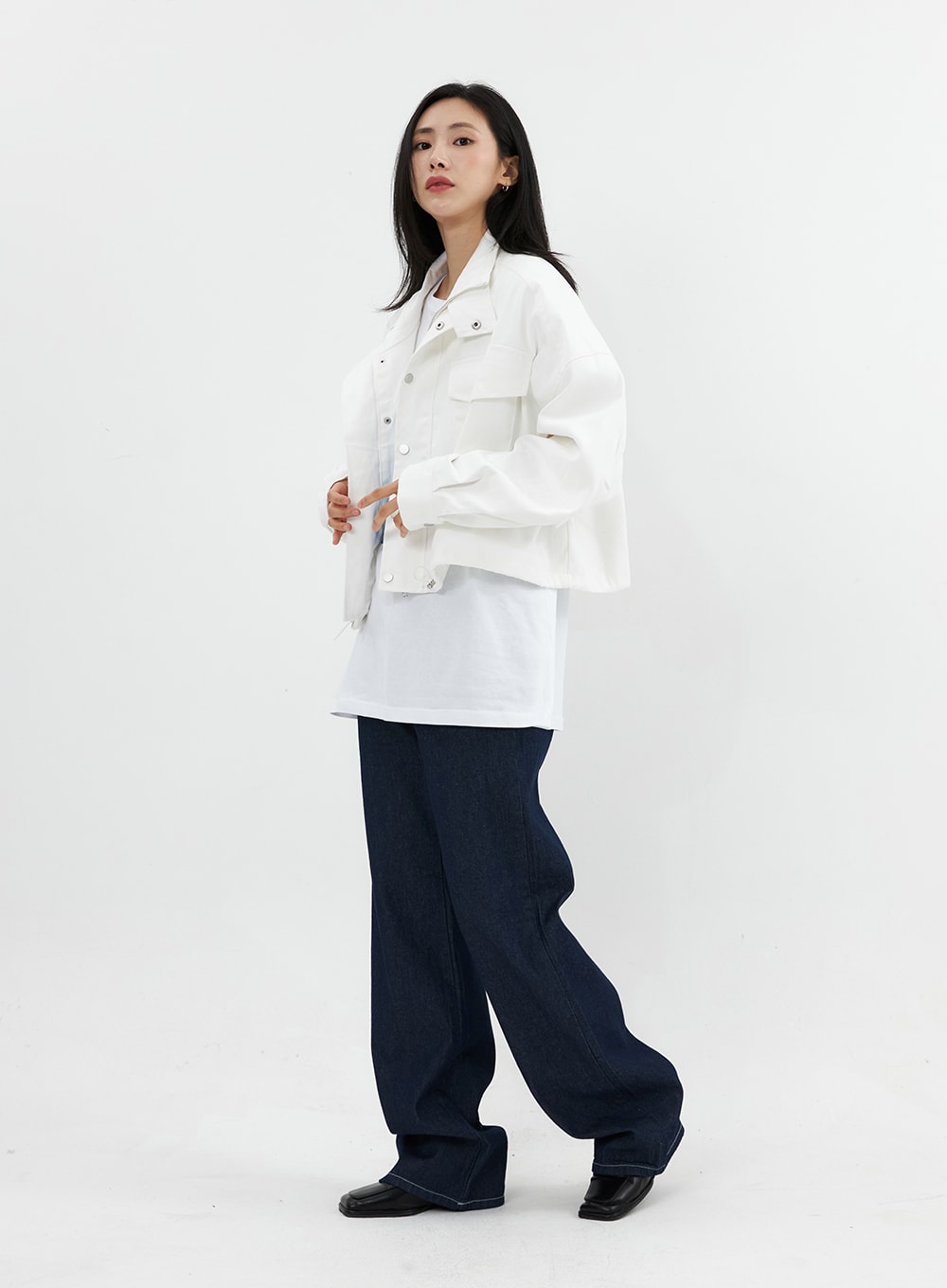 Stitched Jeans OO305 in Blue, side full-length on model, wide-fit dark denim with contrast stitching, voluminous leg, styled with white jacket layered over graphic tee.