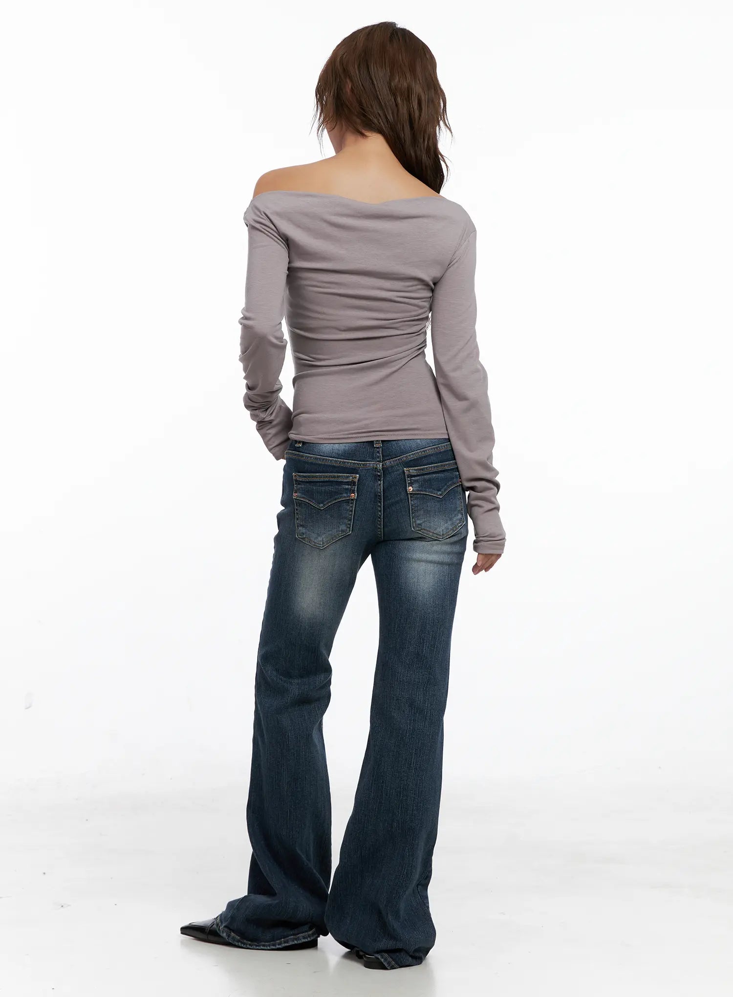 Saanvi Vintage Wash Flare Jeans CS522 in dark blue, back full-body shot on model, paired with grey off-shoulder long-sleeve top, flare leg from knee, back pockets and waistband detail visible.
