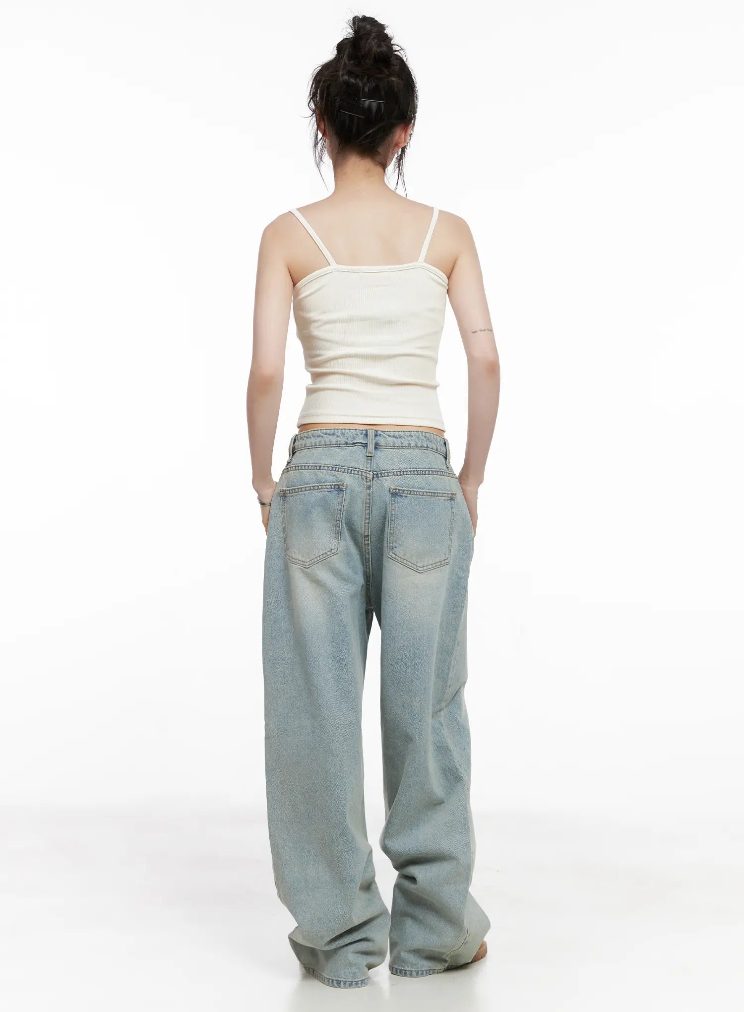 Lilly Light Wash Baggy Jeans CG519 in light blue, full back view on model in cream cami, wide-leg silhouette with back pockets and long hem bunching at tan boots.