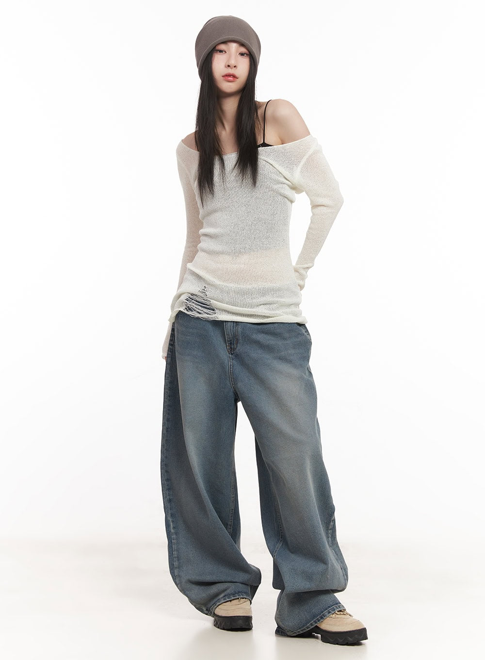 Shelly Washed Baggy Jeans CM518 in blue, full-body front shot on model with hand on hip, wide-fit washed denim with street-style silhouette, paired with ivory off-shoulder knit and beanie.