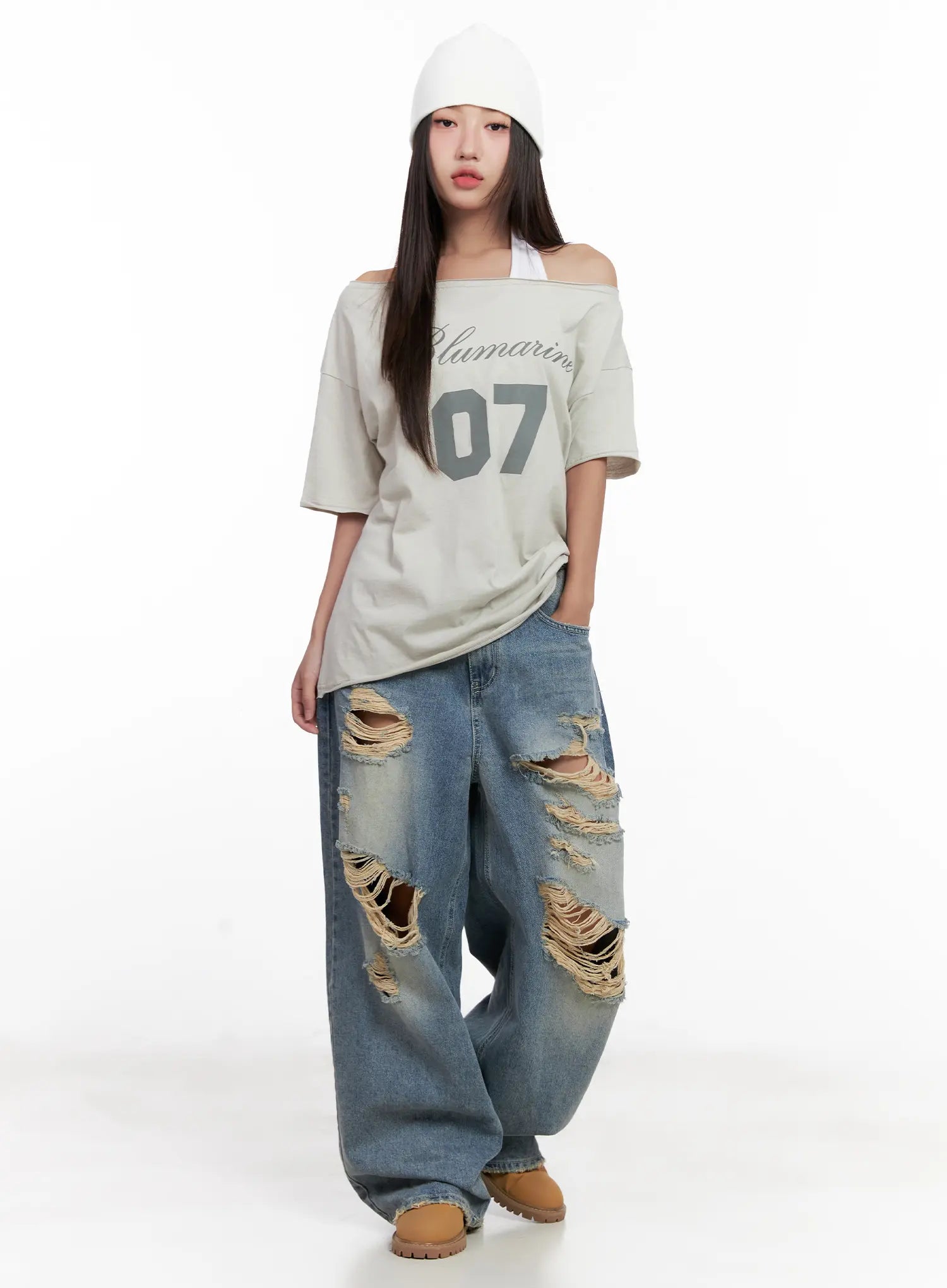 Manon Washed Distressed Wide Jeans CL518 in blue, full-body front editorial shot, styled with off-shoulder number-print tee and white beanie, grunge street outfit.