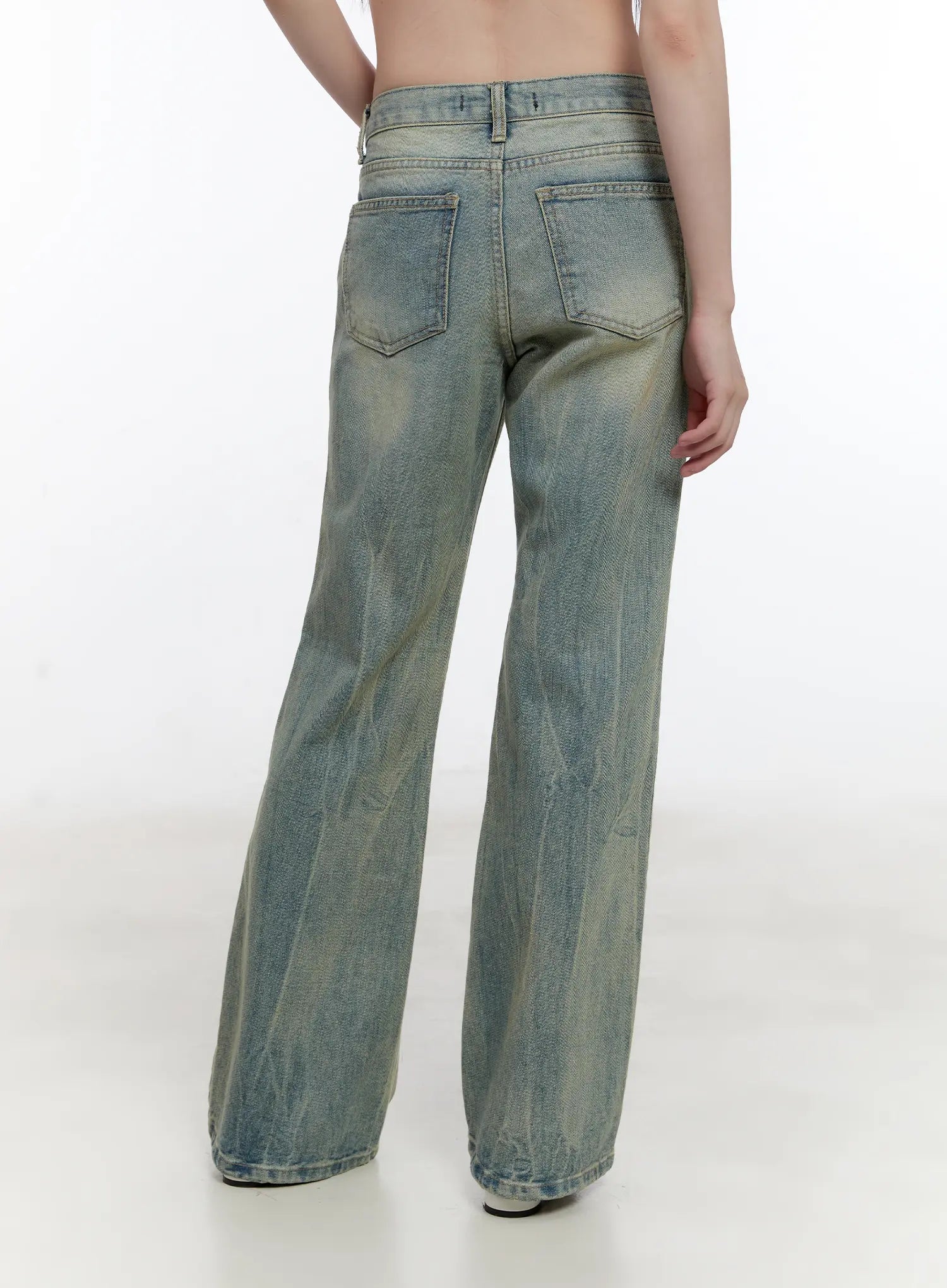 Roa Vintage Blue Flared Denim Jeans CL504 in blue, back view close-up on model, showing two back patch pockets, yellow-toned washed denim, wide-leg flare hem, casual cotton denim.