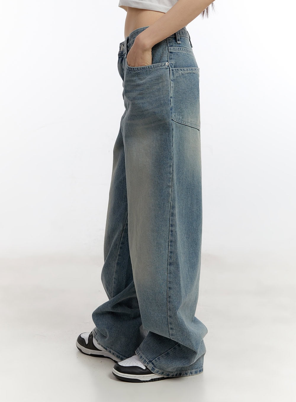 Jillie Washed Baggy Jeans CA508 in blue, side close-up view on model, washed cotton denim highlighting seam detailing and faded wash gradient down wide-fit leg, paired with white sneakers.