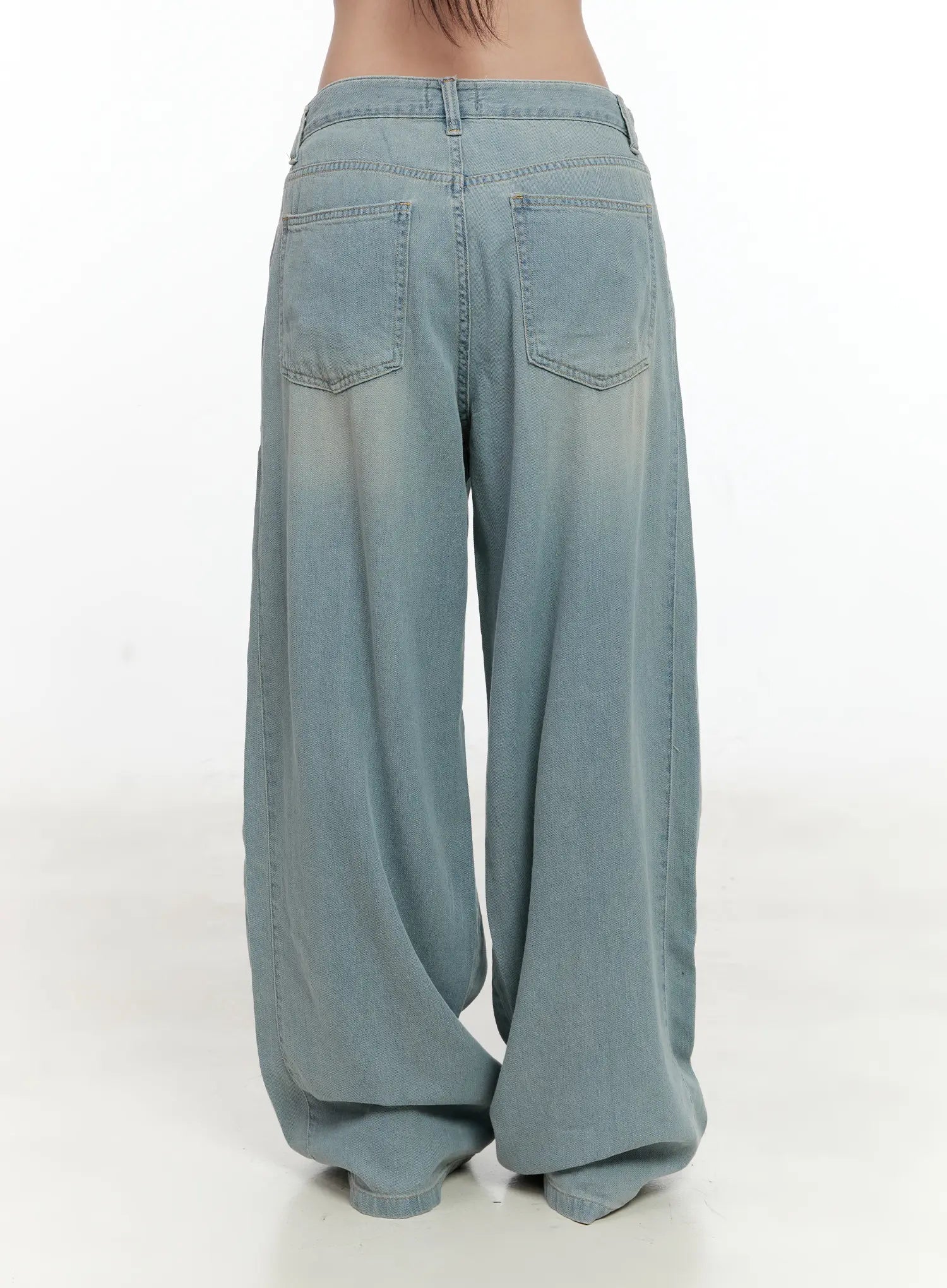 Huening Wide-Leg Jeans CL531 in blue, back product shot on model, showing dual back patch pockets and washed fading across the wide-leg silhouette, floor-grazing length.