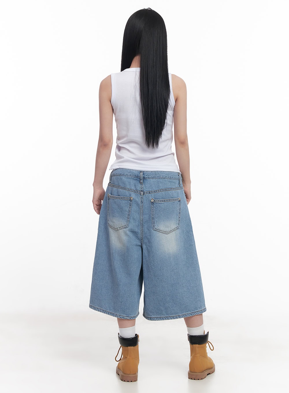 Layered Drawstring Baggy Jorts CY527 in light blue, full back view on model, wide baggy midi denim jorts with dual back pockets and washed fading, paired with white sleeveless top and tan boots.