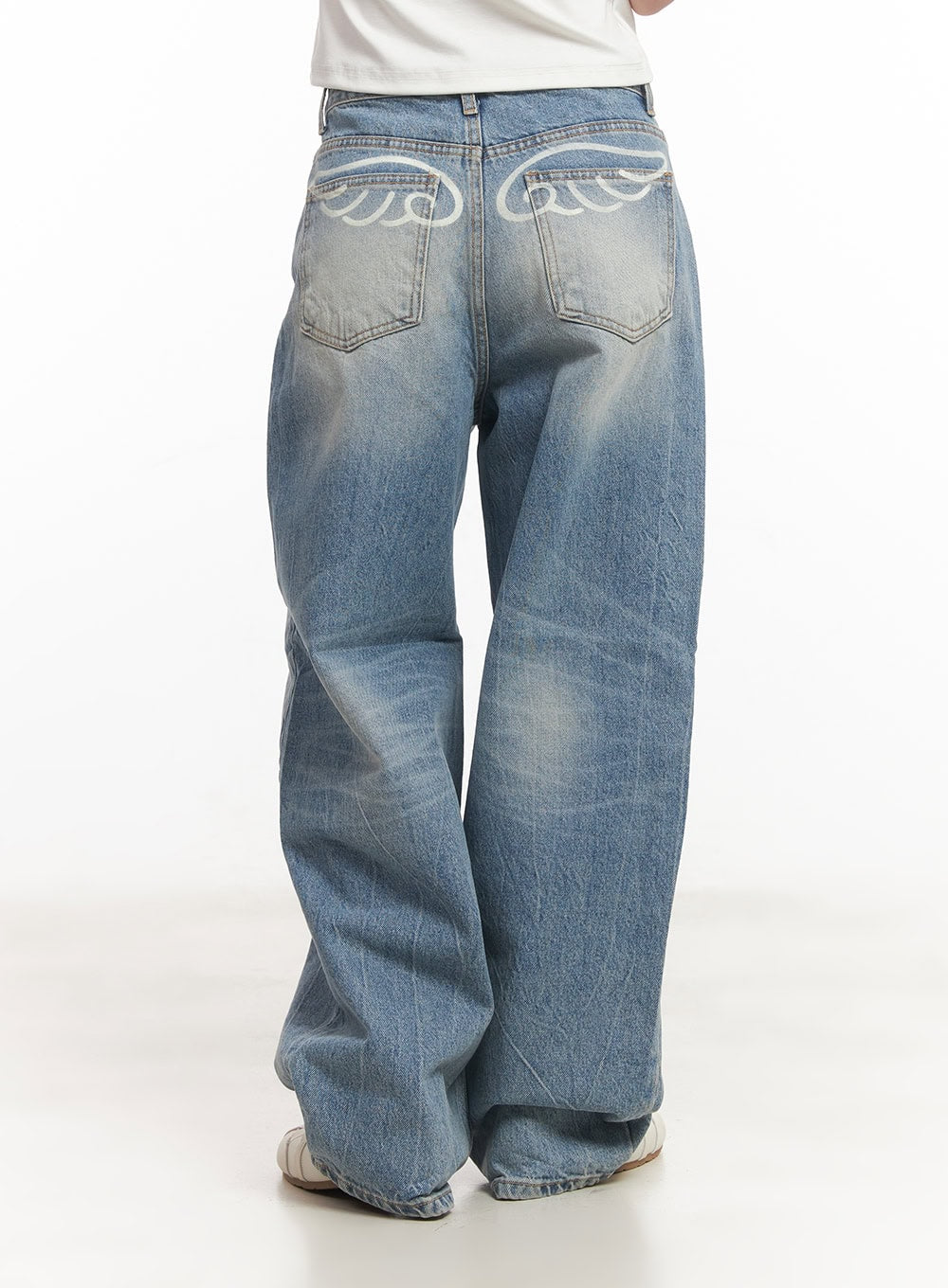 Lumira Back-Detail Washed Wide Leg Jeans CA530 in blue, back full-length product shot on model, white wing graphic on back pockets, wide-leg washed denim with floor-grazing hem.