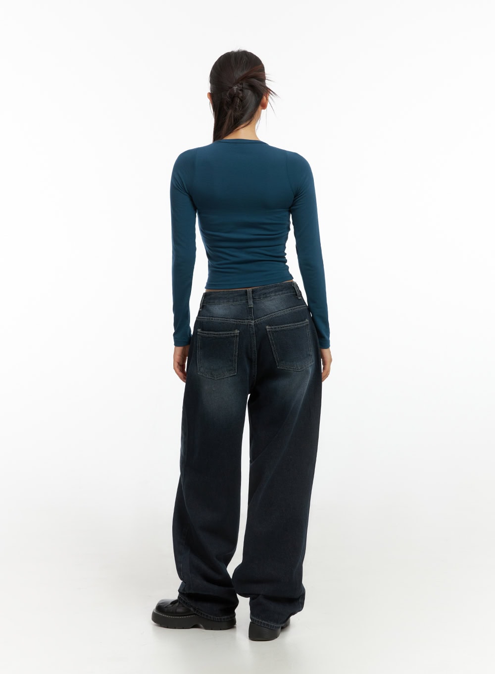 Evelyn Washed Baggy Jeans (Dark Blue) IS402 in dark blue, full back view on model, wide-fit washed denim with dual patch pockets and contrast topstitching, paired with fitted teal long-sleeve.