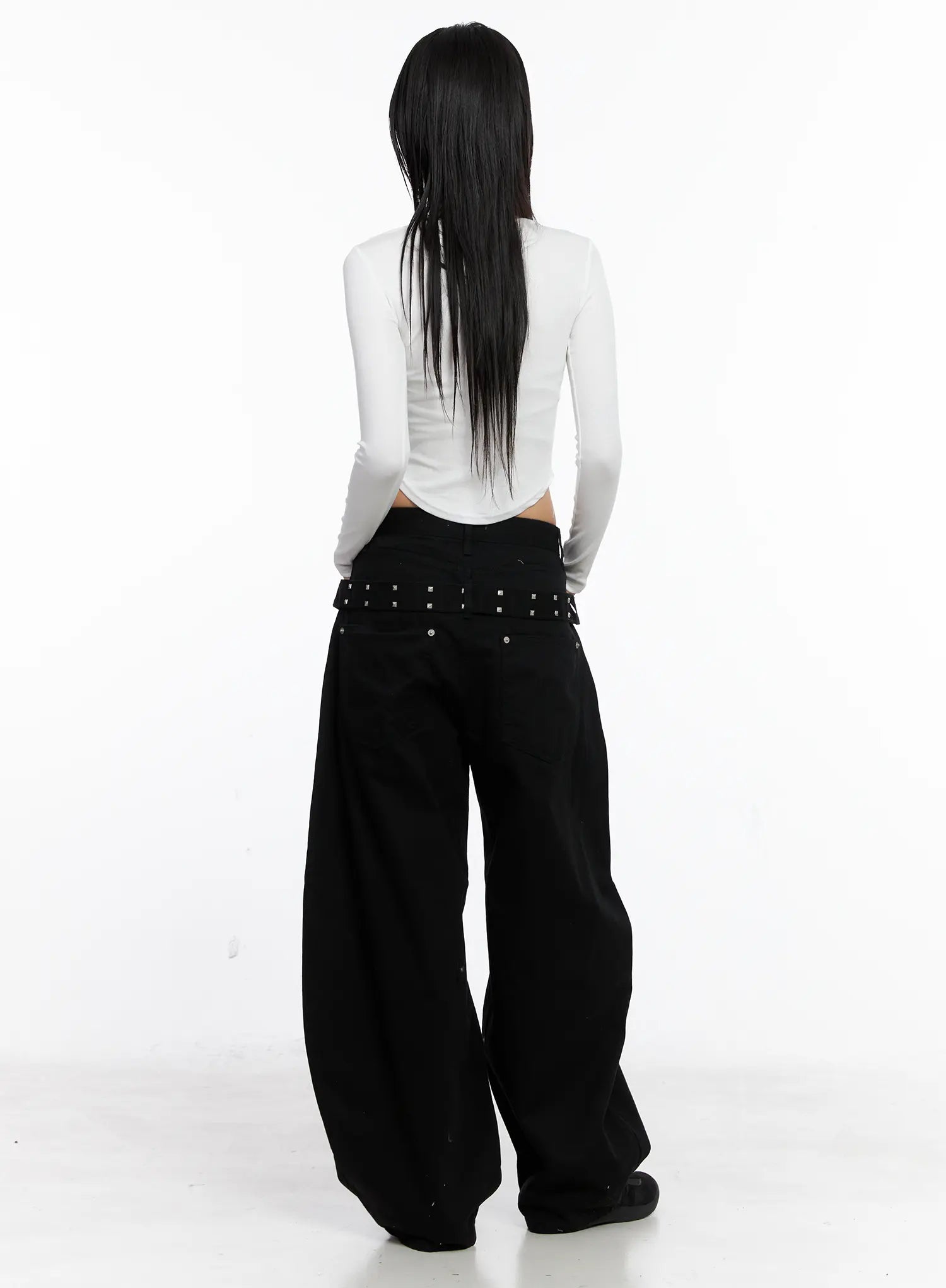 Nana Studded Belt Balloon Jeans CS512 in black, back full-body on model, studded belt detail at waist, paired with white long-sleeve crop top, voluminous balloon leg to floor.