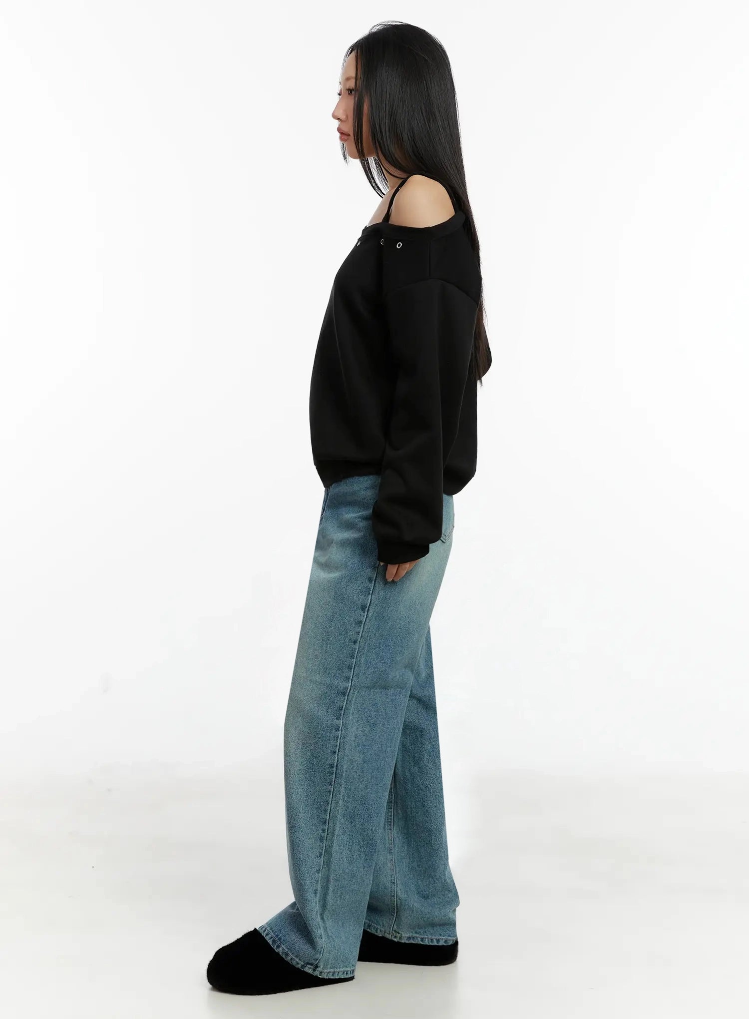 Pixi Straight Leg Jeans ID525 in blue, side full-body shot on model, showing straight long leg silhouette and side seam of washed cotton denim, paired with black off-shoulder sweatshirt and black slides.