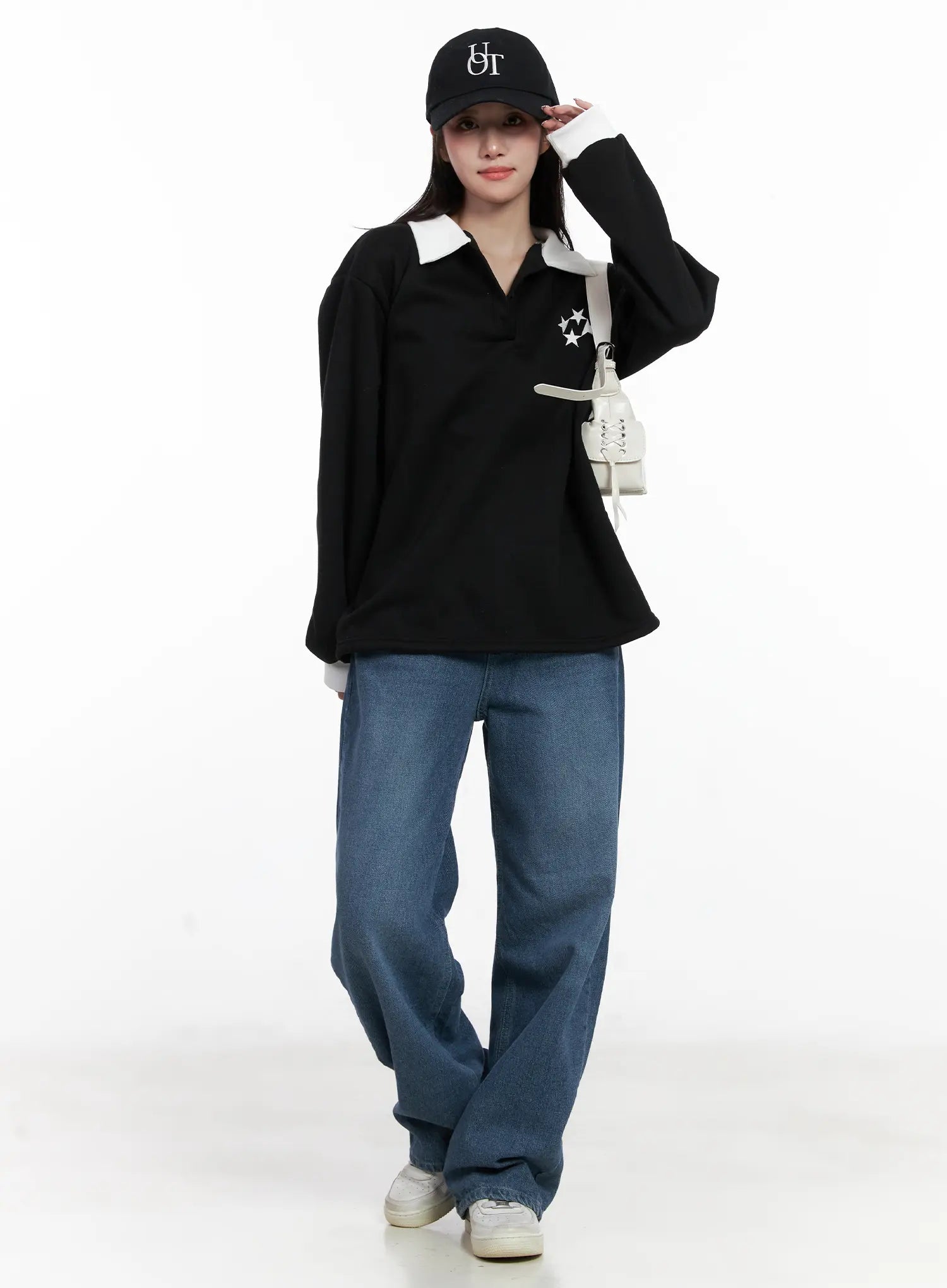 Mariam Baggy Jeans CN526 in blue, full-body front on model, wide-leg washed denim with easy fit, styled with black polo top, cap, and white mini bag.