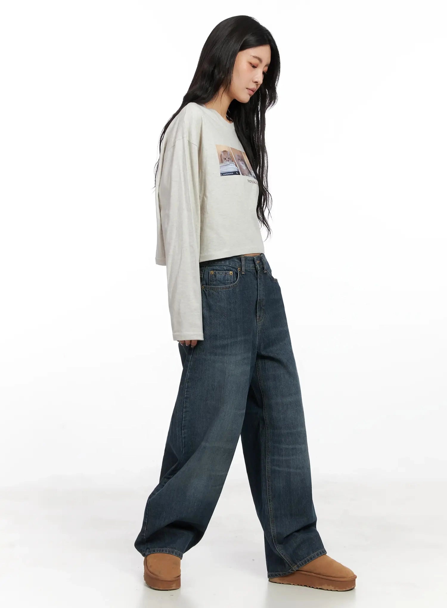 Regina Contrast Stitch Baggy Jeans IN528 in dark blue wash, side view on model walking, wide-leg washed cotton denim showing generous leg volume, styled with oversized crop top and tan boots.