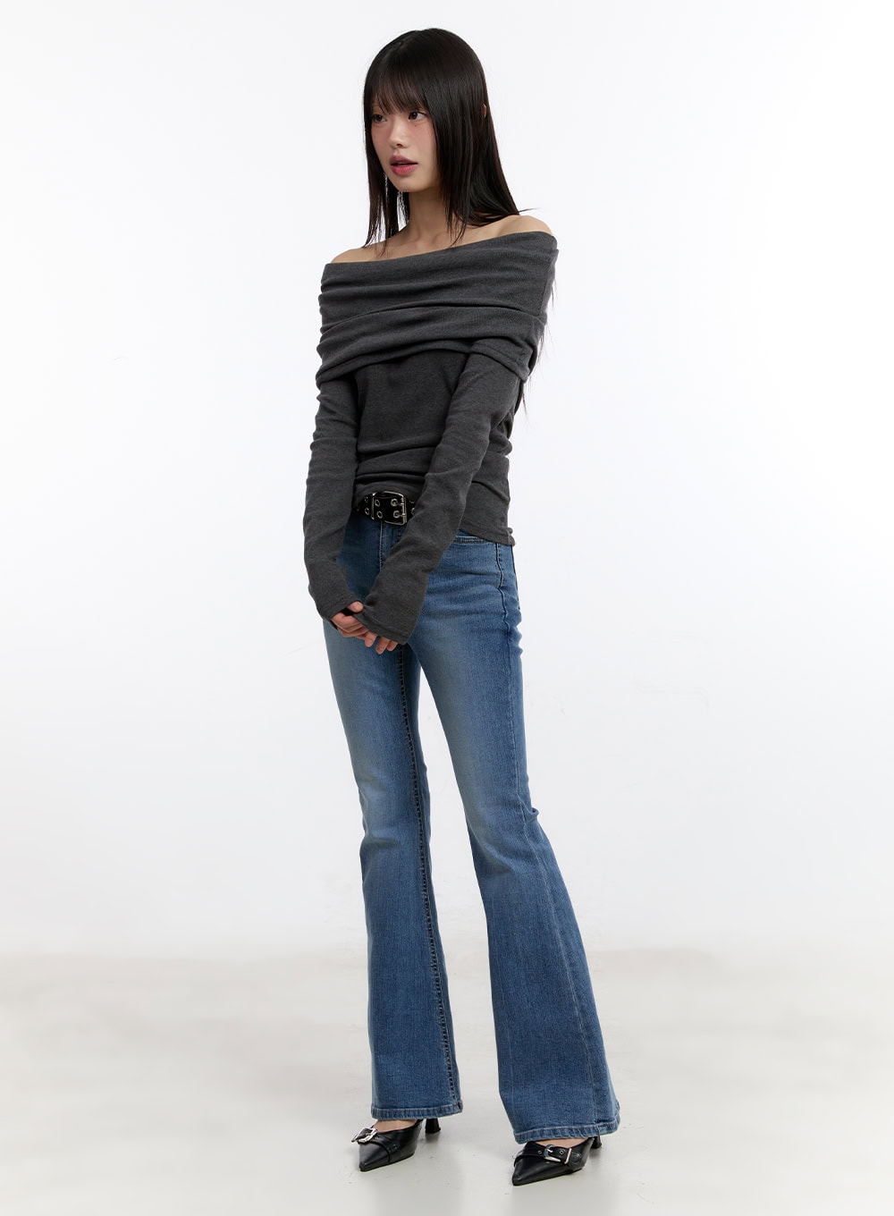 Maris Hip-Pad Bootcut Jeans CA508 in blue, three-quarter front view on model, slim washed denim bootcut jeans styled with grey off-shoulder top, studded belt, and black heels.