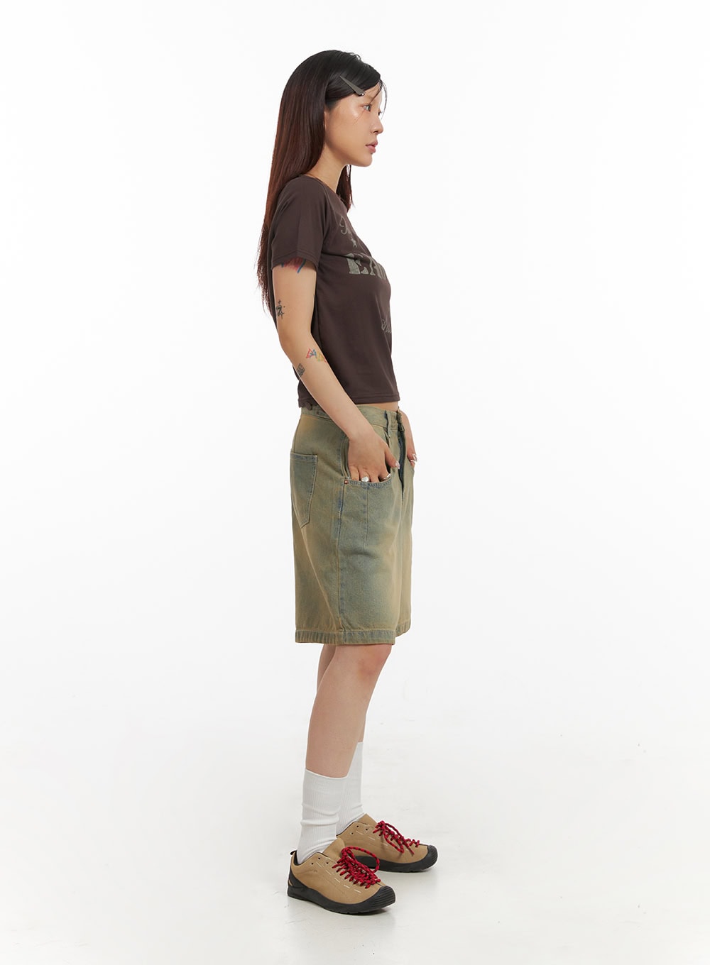 Vintage Washed Baggy Jorts IY410 in light blue, full-length side view on model, wide baggy silhouette and knee-length cut visible, paired with brown graphic crop tee and hiking sneakers.
