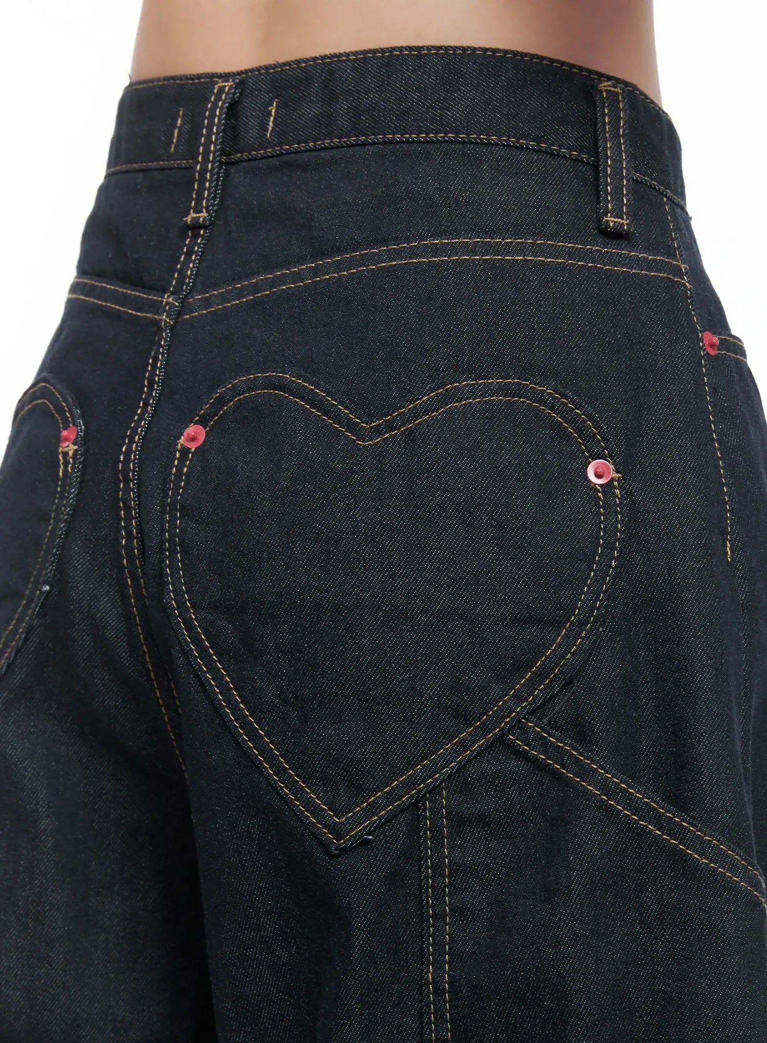 Heart Pocket Balloon Jeans CS503 in dark indigo, back detail close-up, heart-shaped rear pocket with yellow topstitch outline, red rivets, and contrast stitching on cotton denim.