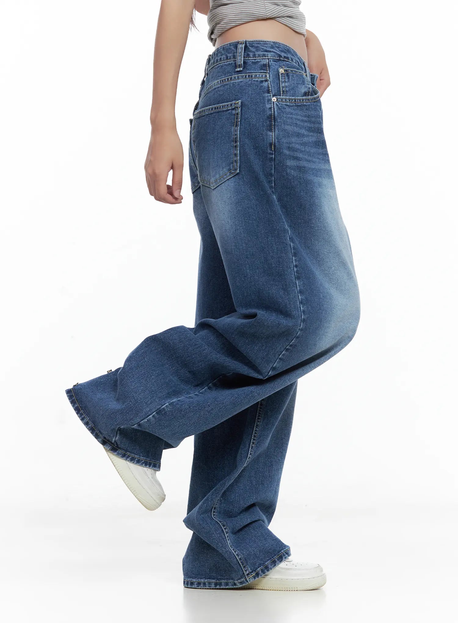 Hayoung Washed Wide-Leg Denim Jeans CL509 in dark blue, angled side view on model with leg raised, rear pocket and washed fade visible, wide sweeping leg silhouette, paired with cropped top.