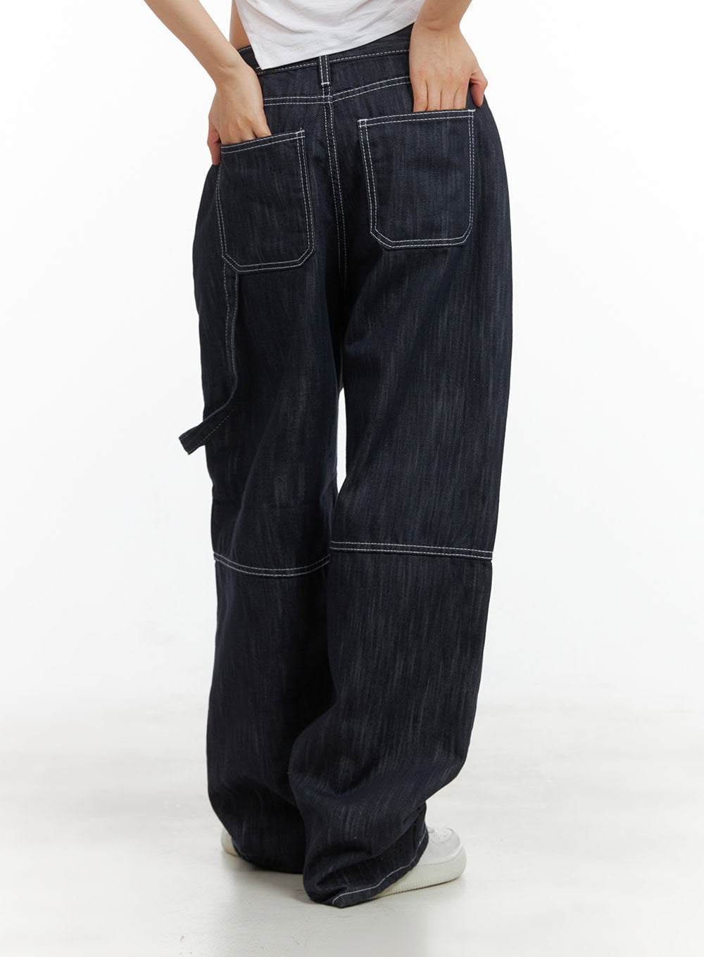 Low-Rise Strap Baggy Jeans CY414 in dark blue, rear three-quarter close-up showing two large back patch pockets with white contrast stitching and carpenter loop detail.