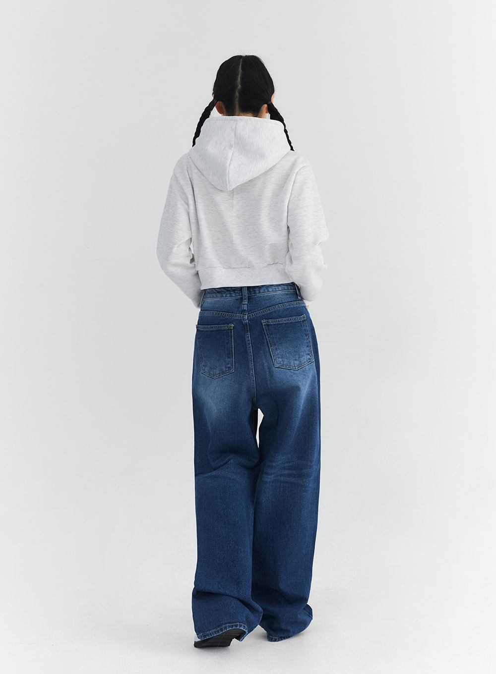 Washed Blue Wide Jeans CN301 in blue, full-length back view on model, showing dual patch pockets, wide-leg silhouette, washed indigo denim, and relaxed regular-length hem pooling over silver shoes.