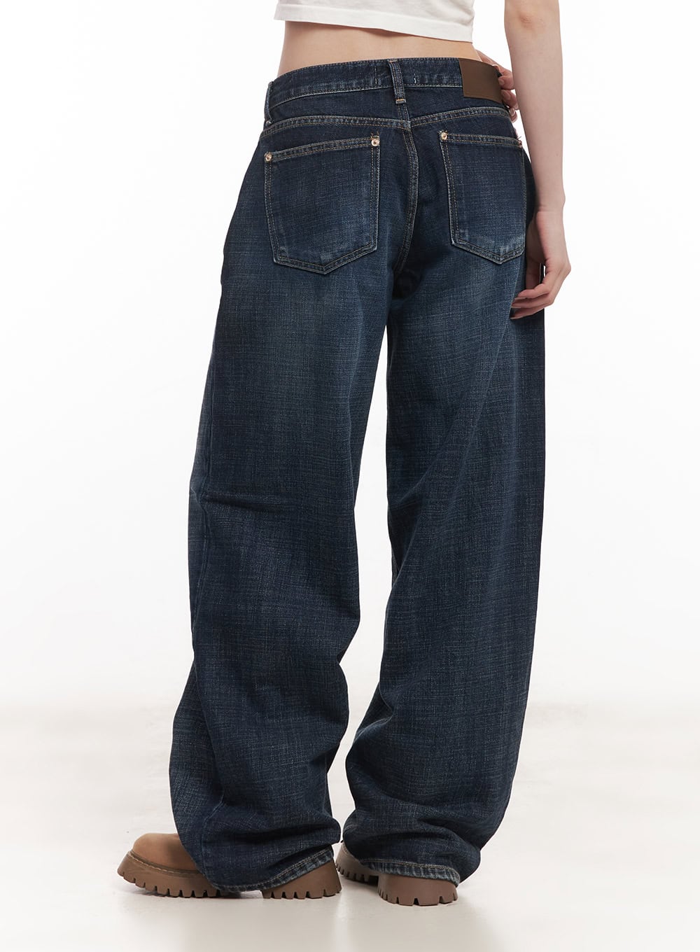 Annie Washed Wide-Leg Jeans CM518 in dark blue, back close-up on model, two back pockets with contrast stitching, washed denim texture, wide-leg hem pooling over brown boots.