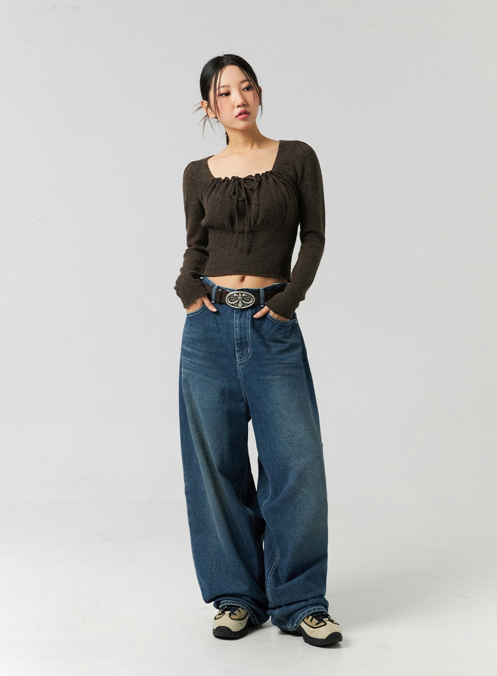 Washed Cotton Wide Leg Jeans CO323 in blue, full-body front on model with hands in pockets, ultra-wide leg washed denim floor-grazing length, styled with brown ruched knit crop top and belt.
