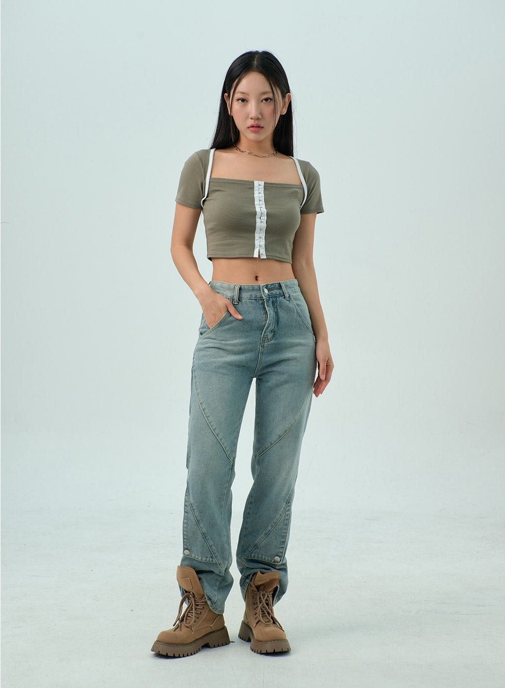 Straight Leg Jeans CY330 in light blue wash, full-length front shot on model with one hand in pocket, straight-fit washed denim with geometric seam detailing, olive crop top and tan boots.
