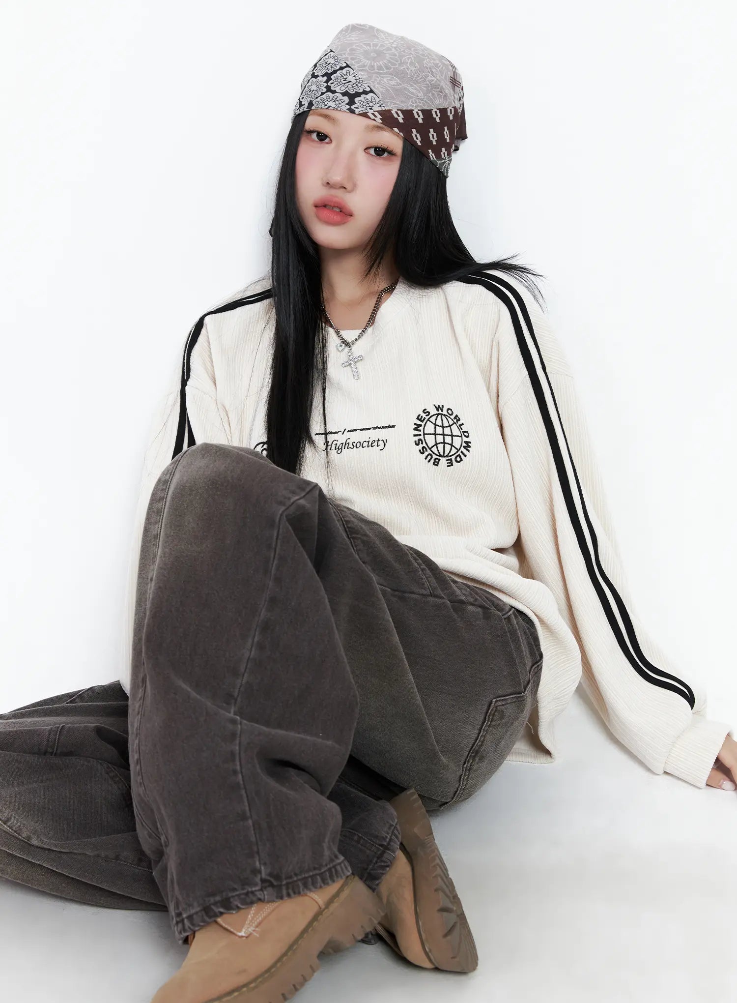 Elia Washed Baggy Jeans CN528 in dark brown, seated editorial shot on model, relaxed wide-leg pooling at ankle, washed finish with cargo pocket, paired with cream sweatshirt.