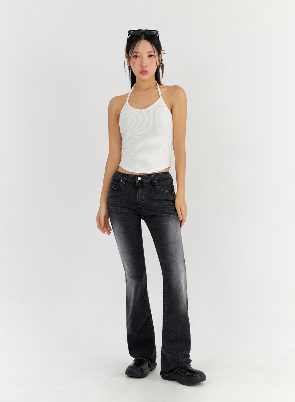 Bootcut Washed Jeans CO325 in dark gray, full-body front view on model, slim bootcut washed denim, low-rise waist, styled with white ribbed halter top and sunglasses on head.